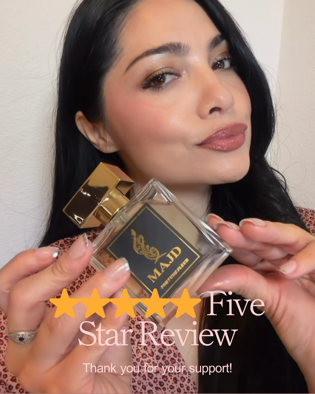 A woman with long dark hair holding a perfume bottle labeled 'MAJD' and 'Fortune Effect.' She has makeup with shiny eye shadow and glossed lips. The image contains a five-star review graphic and the text 'Five Star Review. Thank you for your support!'