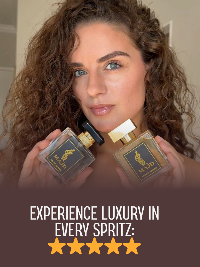 A woman with curly hair holds two perfume bottles labeled 'MAJD,' looking at the camera with a slight smile.