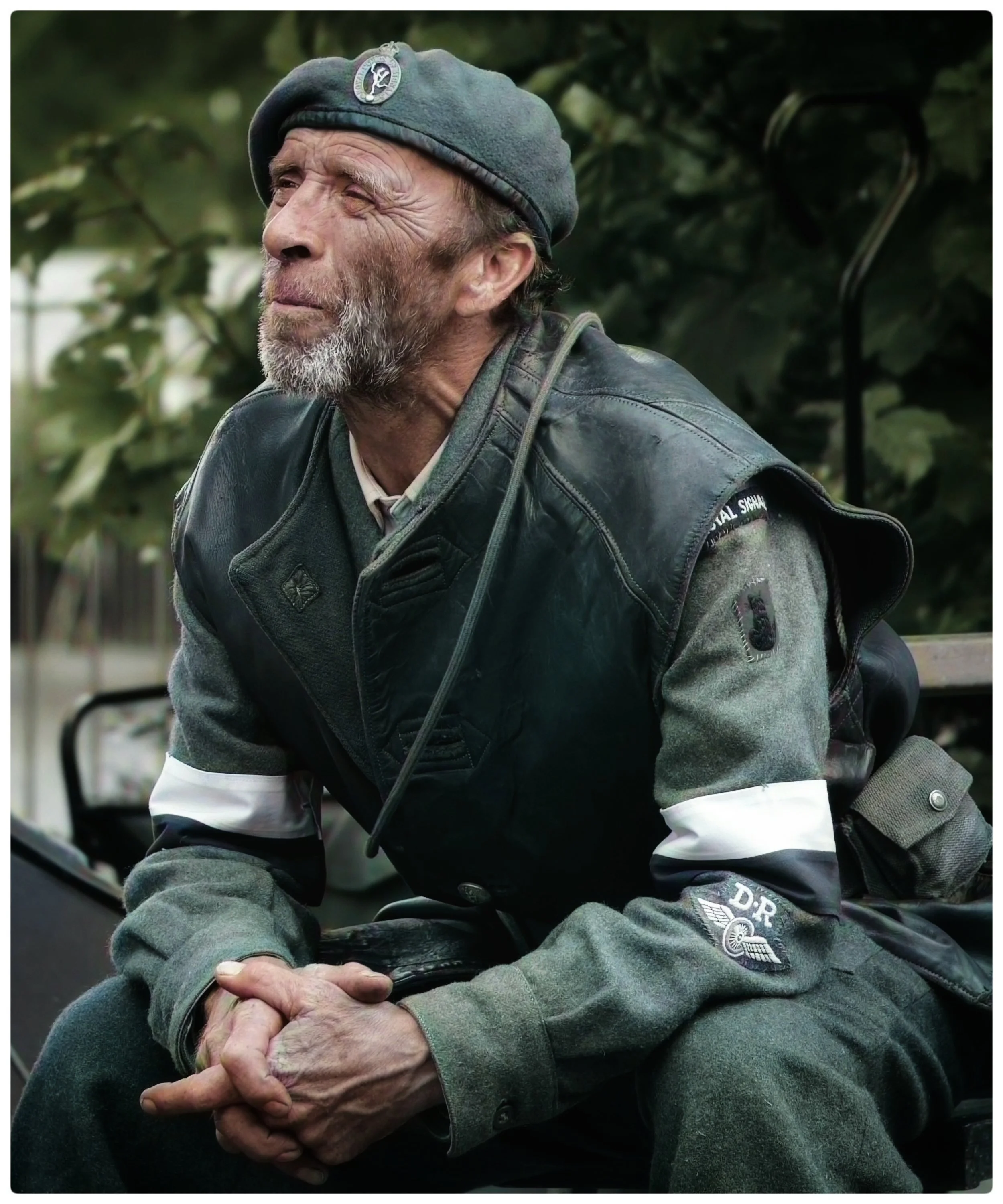A senior man wearing a cap, with a contemplative expression.