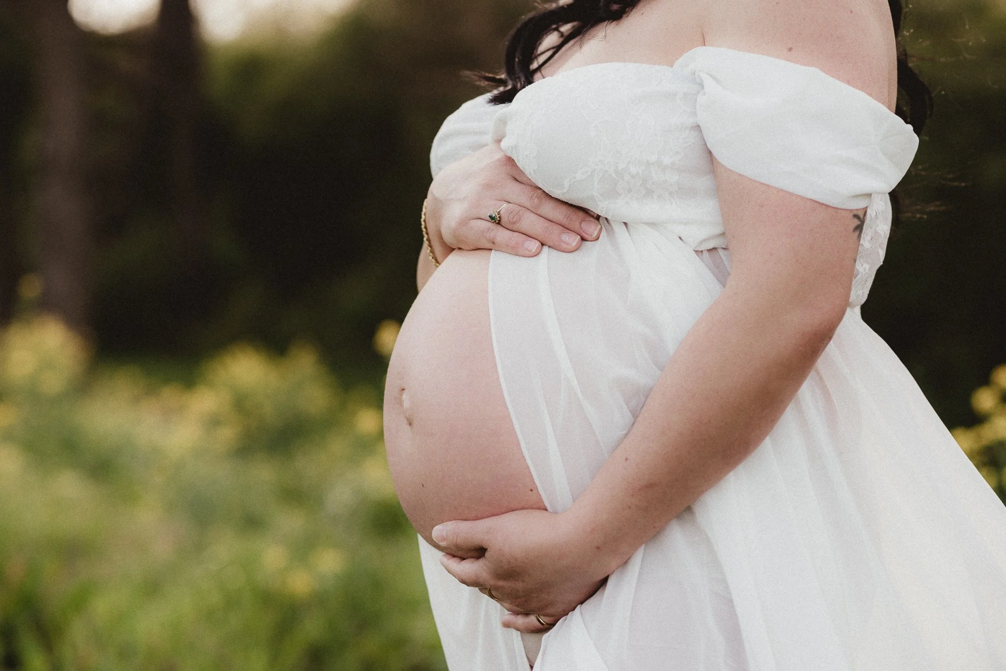Pregnant mother in a white dress during an outdoor maternity photography session in Middle Tennessee.