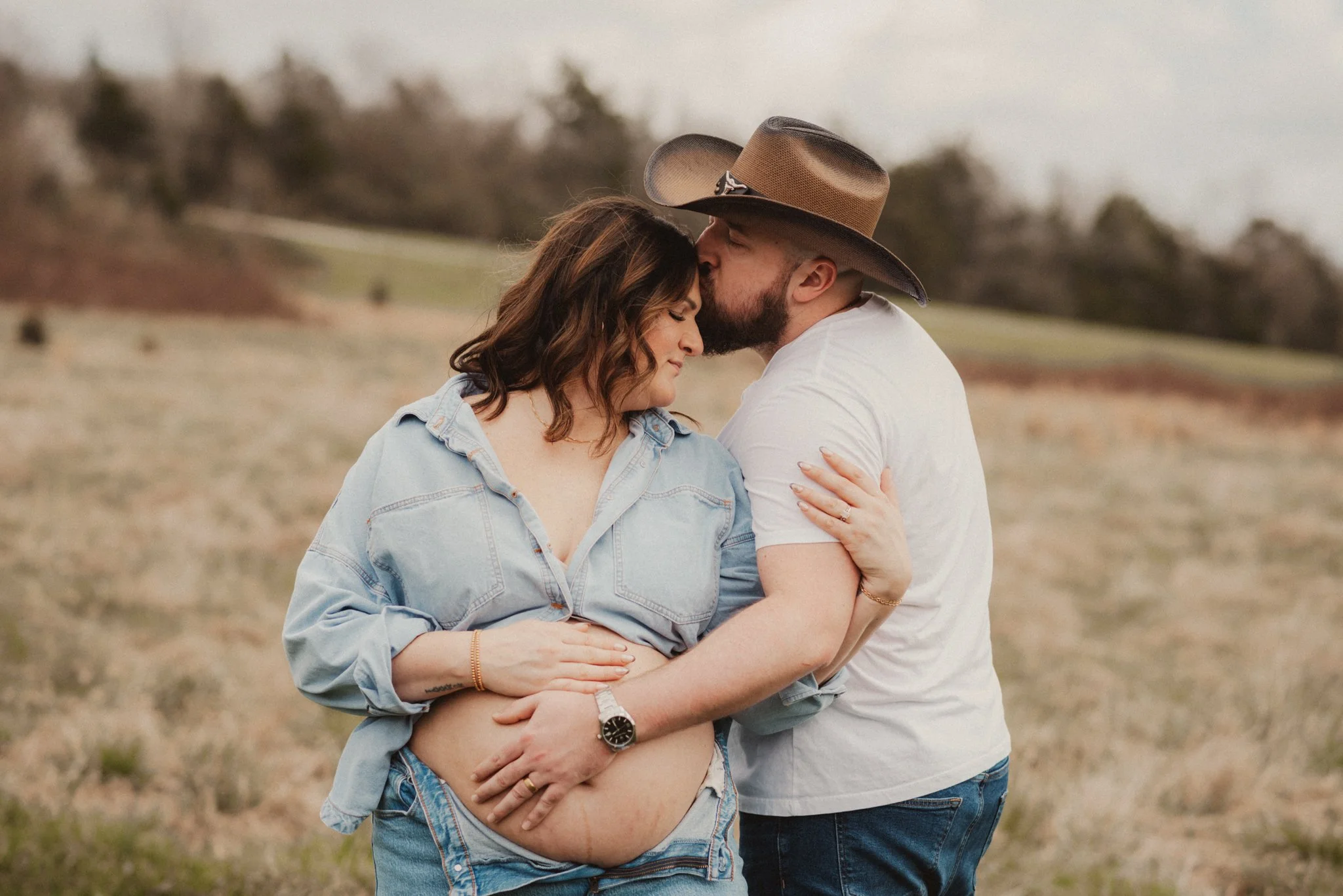 Expecting parents embracing outdoors during a maternity photography session in Middle Tennessee.