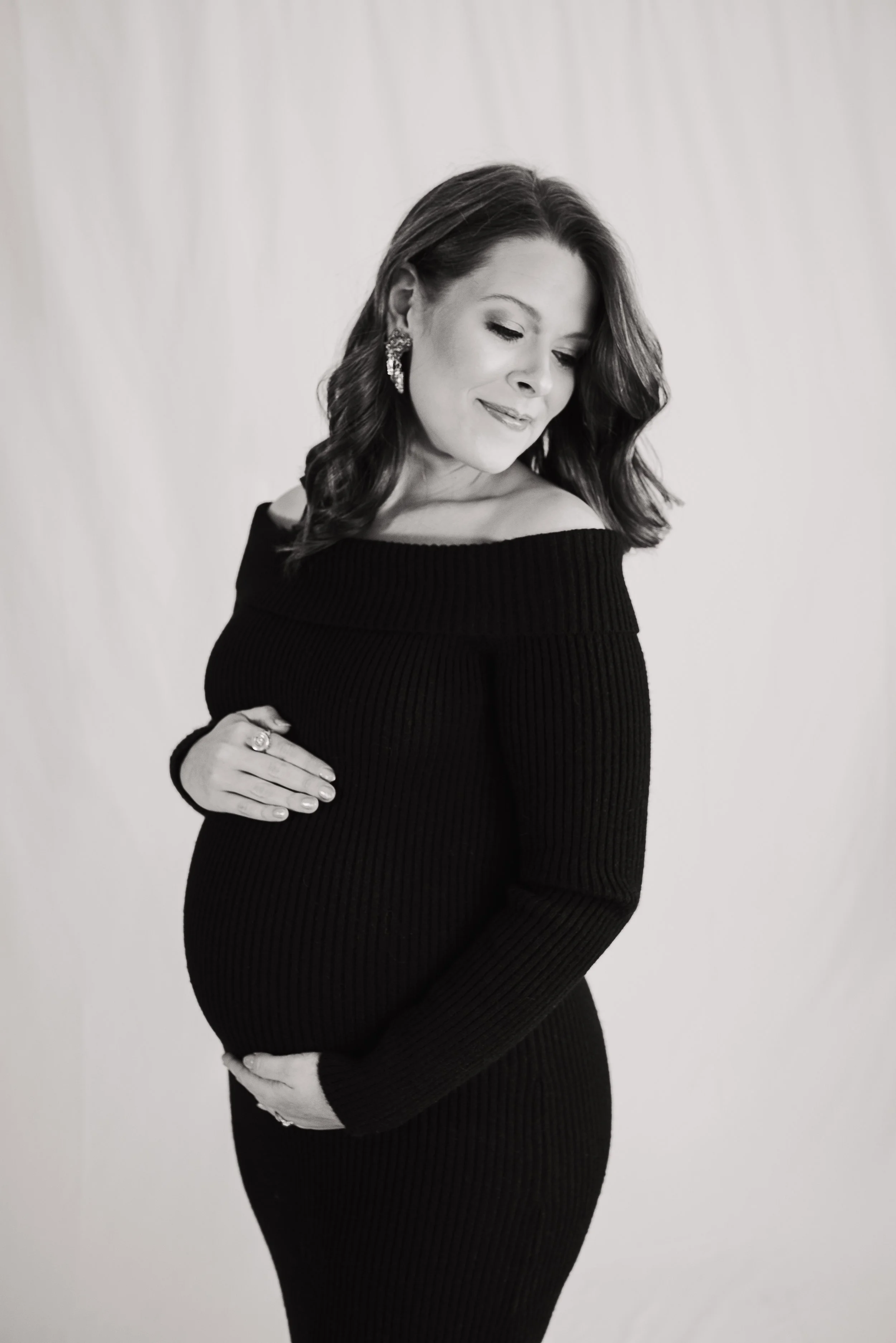 Pregnant mother in a black dress during a studio maternity photography session.