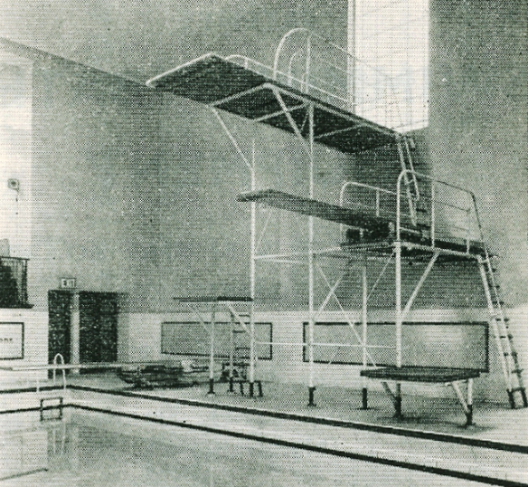 An indoor high diving platform with multiple levels overlooking a swimming pool.