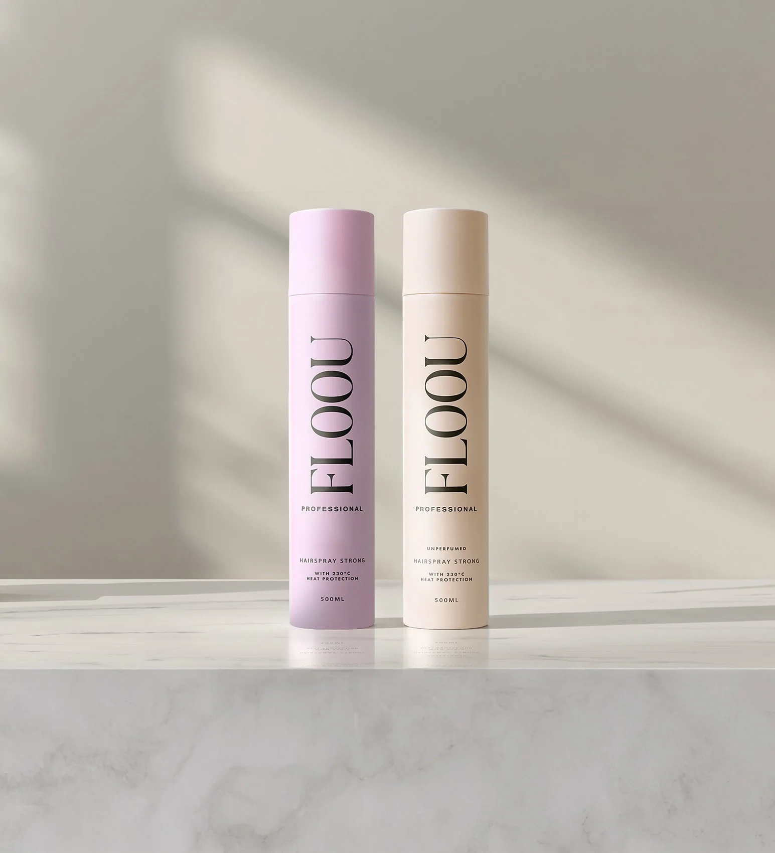 Kaksi hairspray-pulloa, toinen vaaleanpunainen ja toinen vaalea, seisovat pöydällä. Pulloa käyttävät 'FLOOU' tuotemerkki ja ne on suunniteltu ammattilaisille, sisältävät 500 ml.