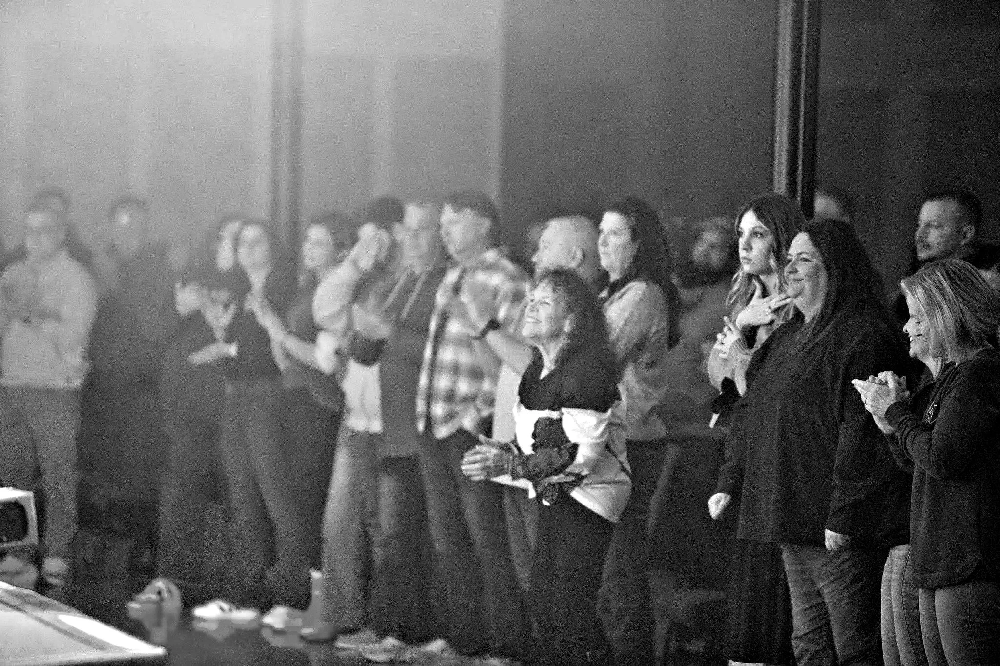 Church family standing together in worship at Merge Church