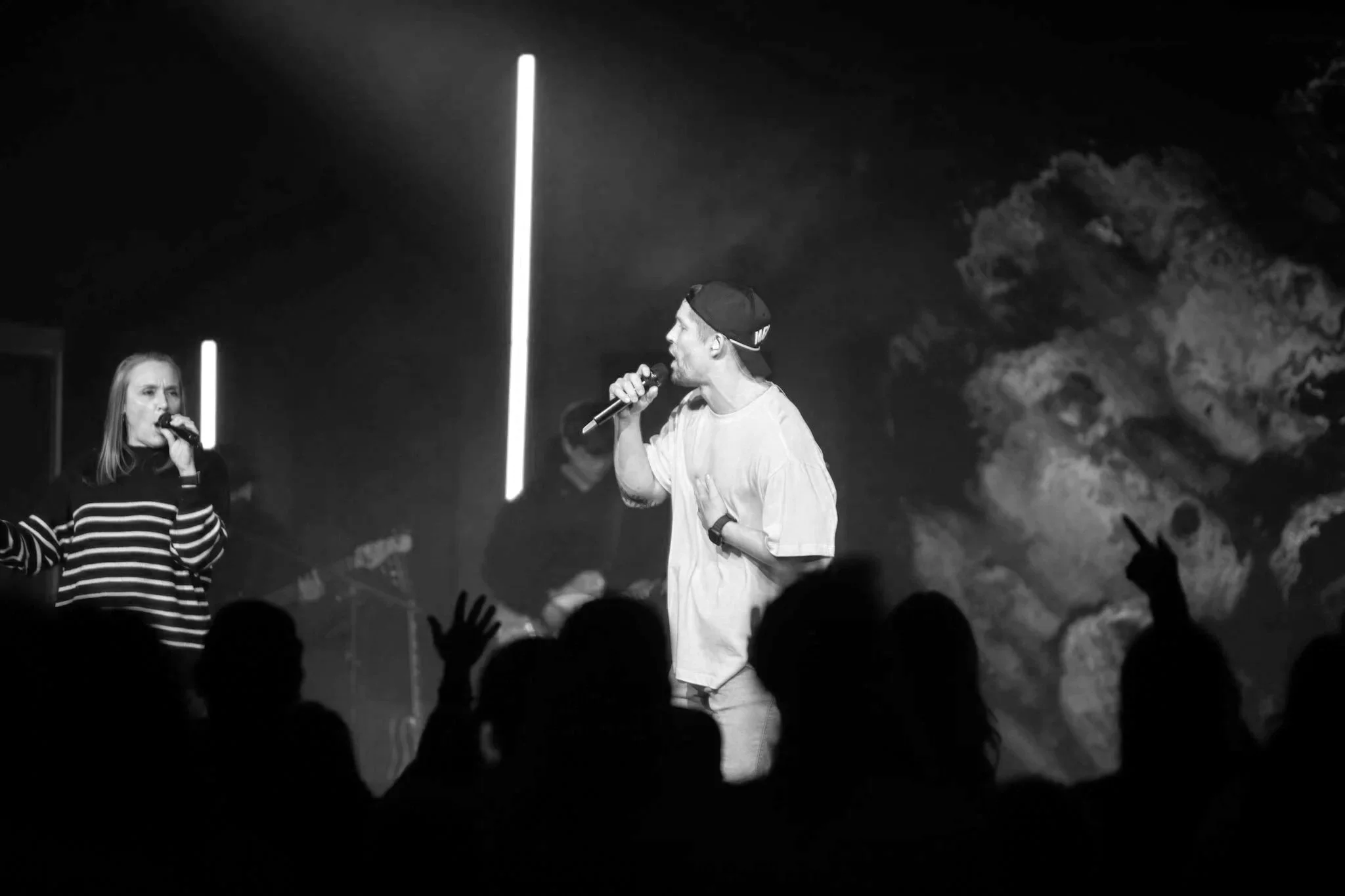 Worship leader singing during a Sunday service at Merge Church