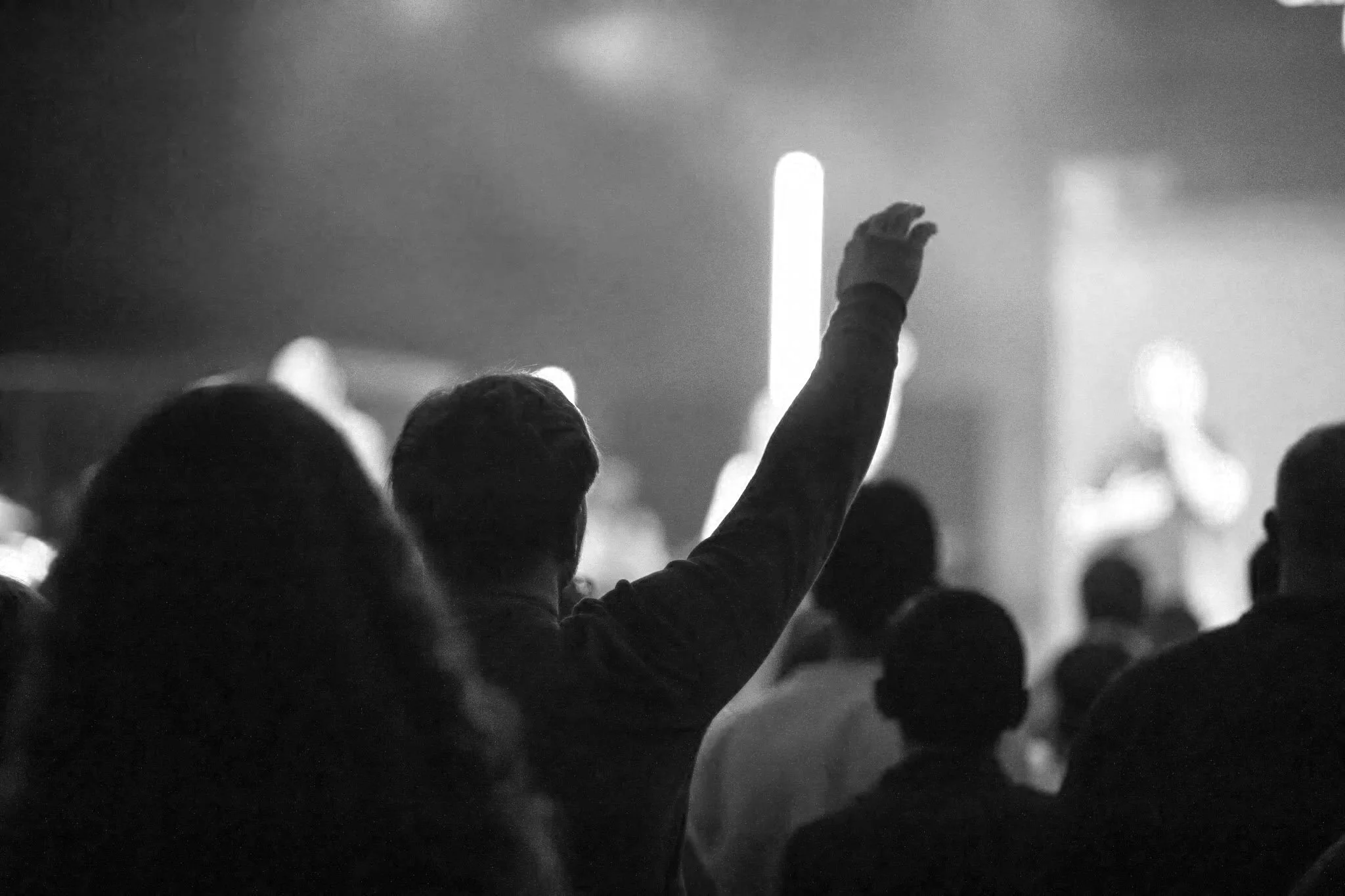 Worshipers raising their hands during a Sunday service at Merge Church