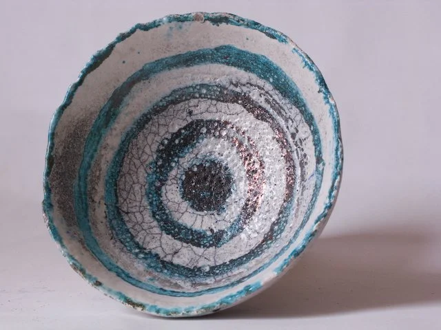 Ceramic bowl with concentric circles of crackle glaze pattern in blue, black, and white colors