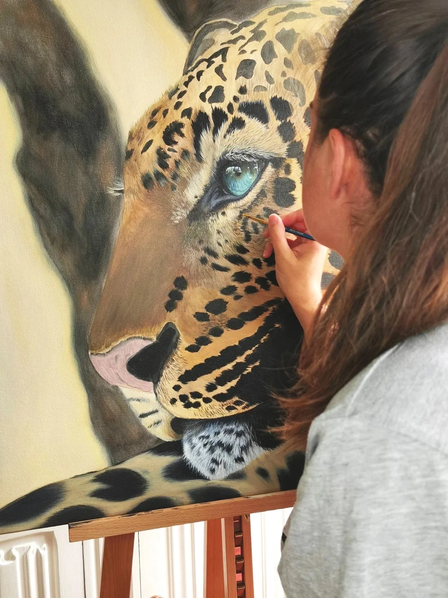 A close up image of a large painting in progress of a jaguar.