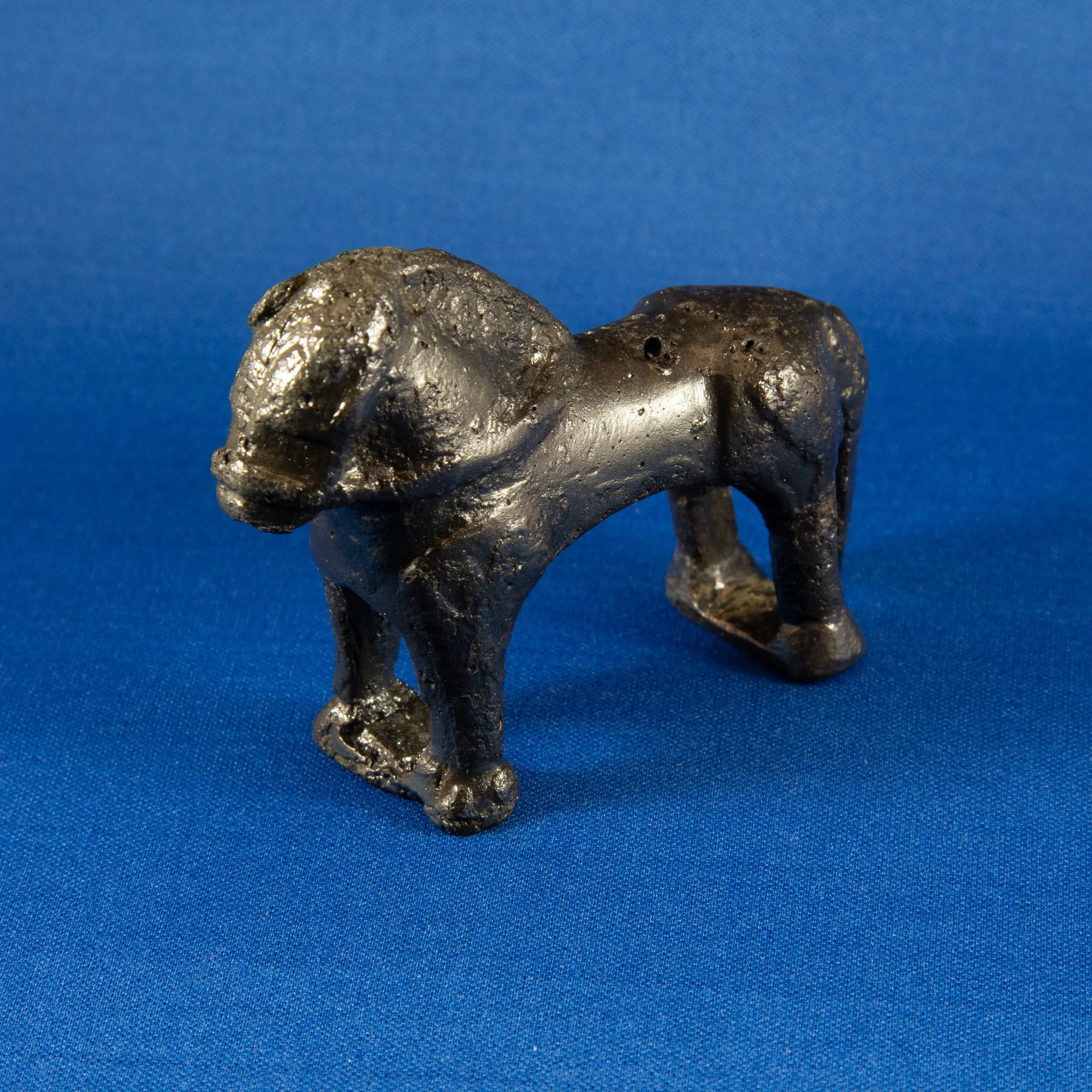 Small black elephant figurine on a blue background