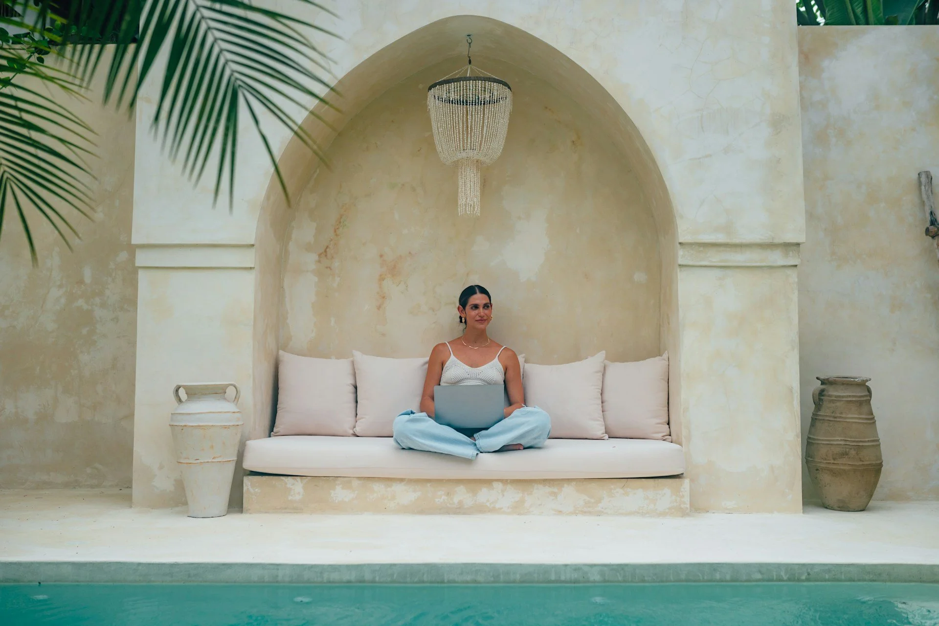 lady by pool with laptop working