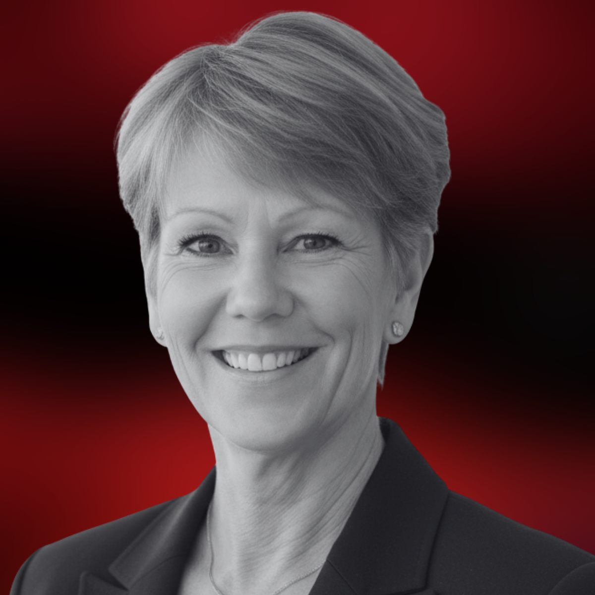 Black and white portrait of a smiling woman with short hair, wearing a blazer and earrings, against a red and black gradient background.
