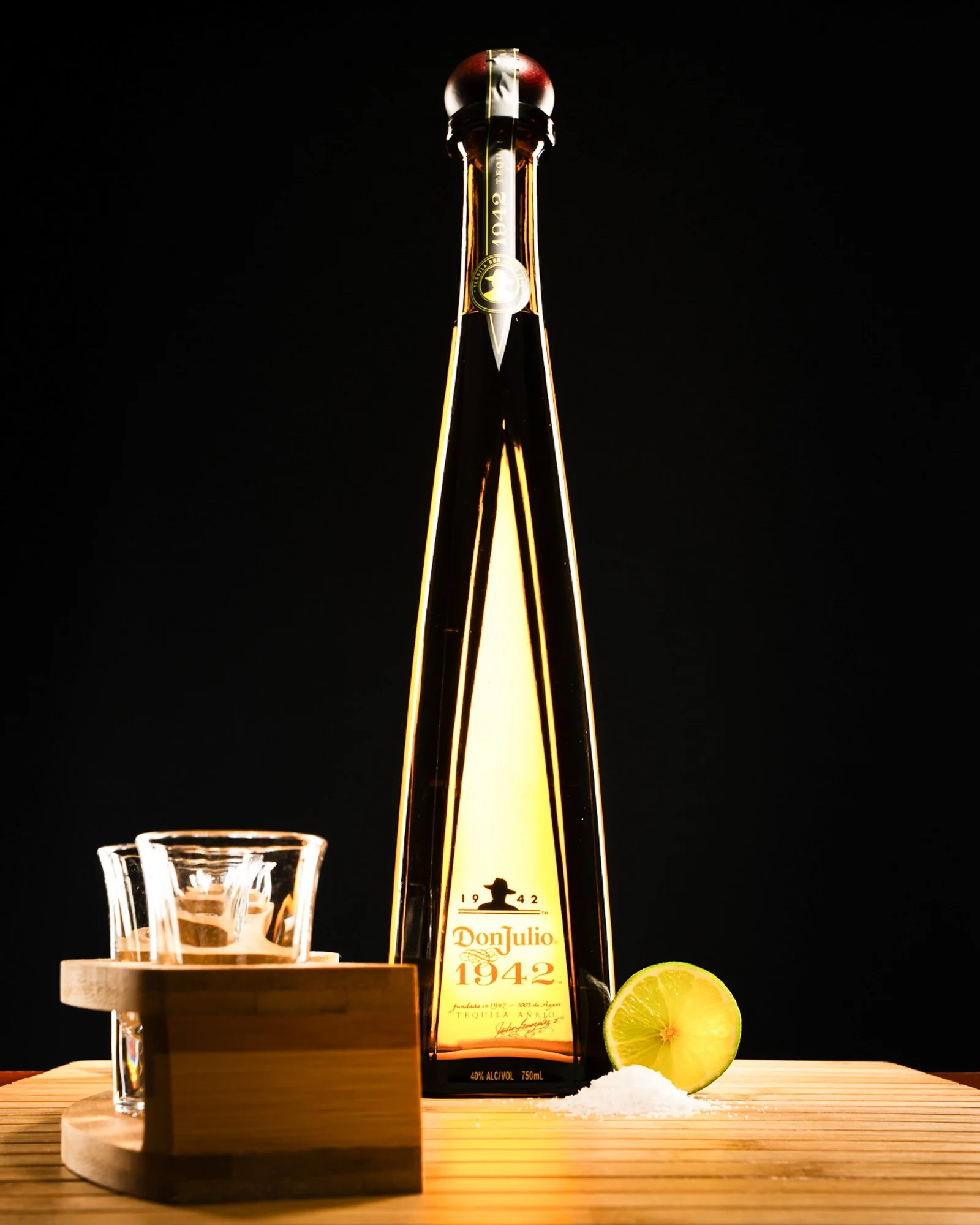 Premium Don Julio 1942  bottle styled with a shot glass and lime.