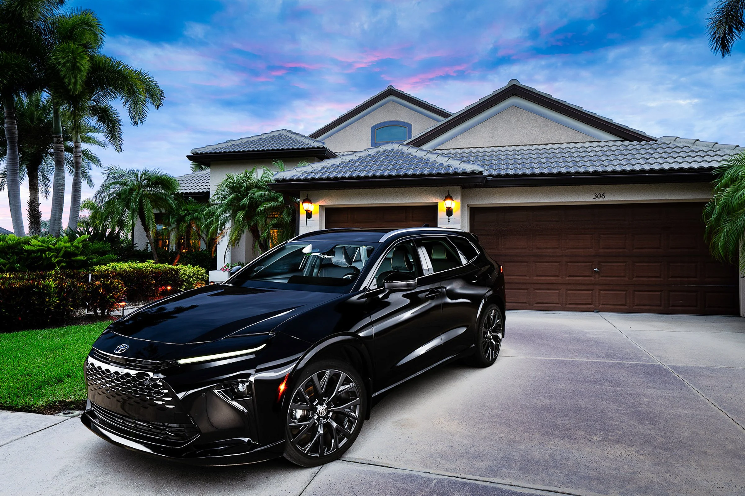 Black automobile photographed outside a residential garage.
