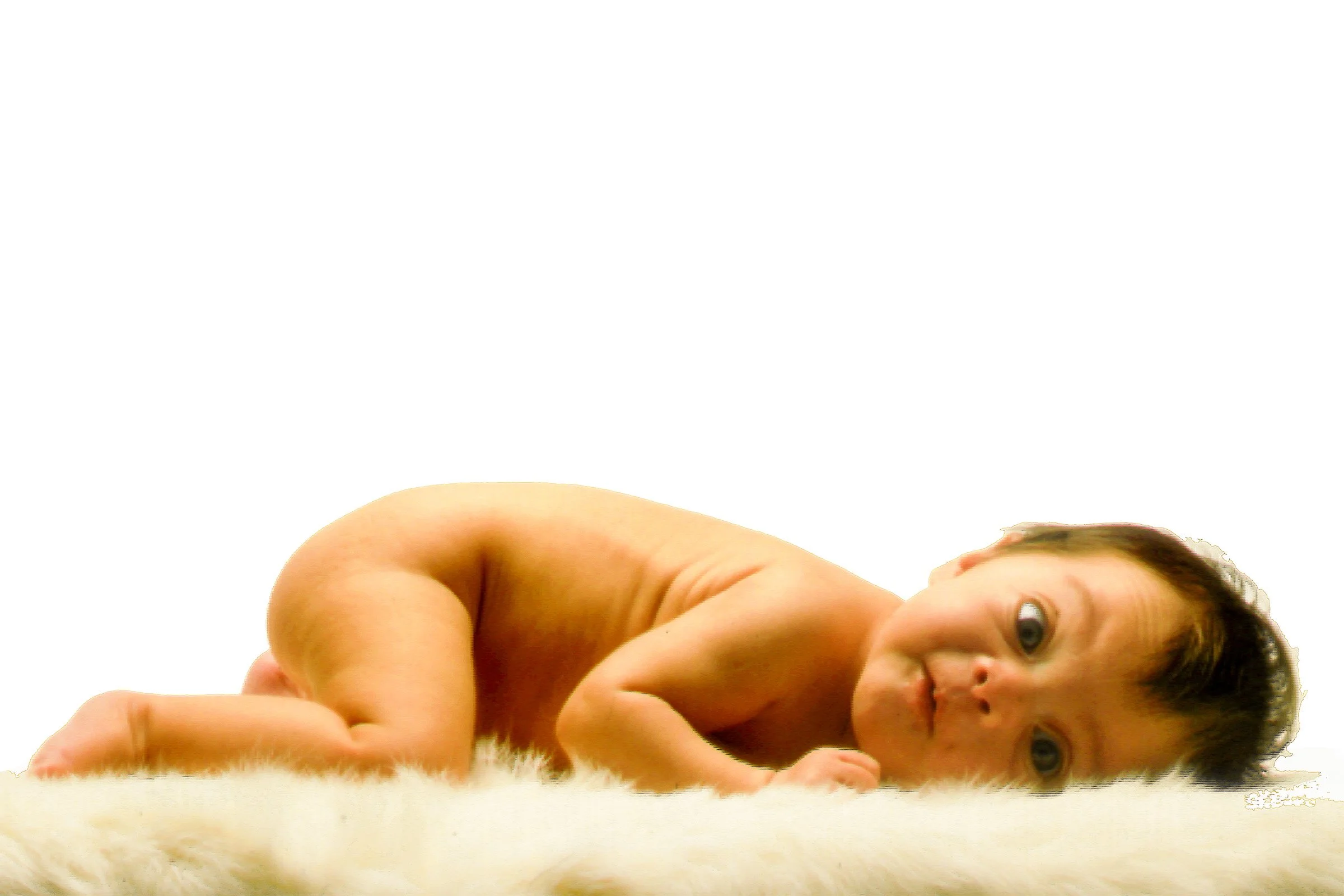 Baby lying on a light-colored rug in a simple lifestyle portrait.