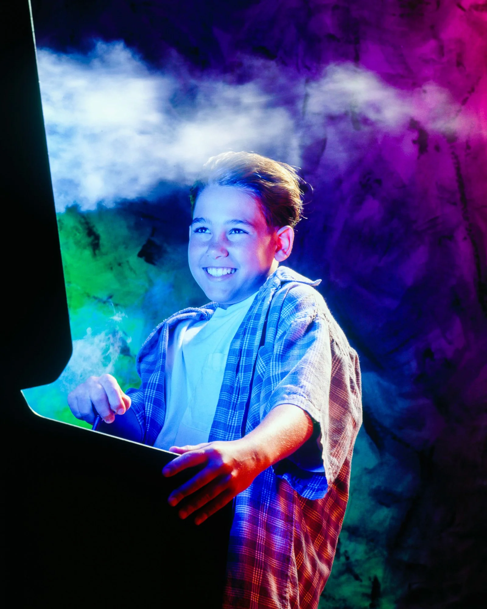 Child illuminated by colorful stage lighting in a creative lifestyle portrait.