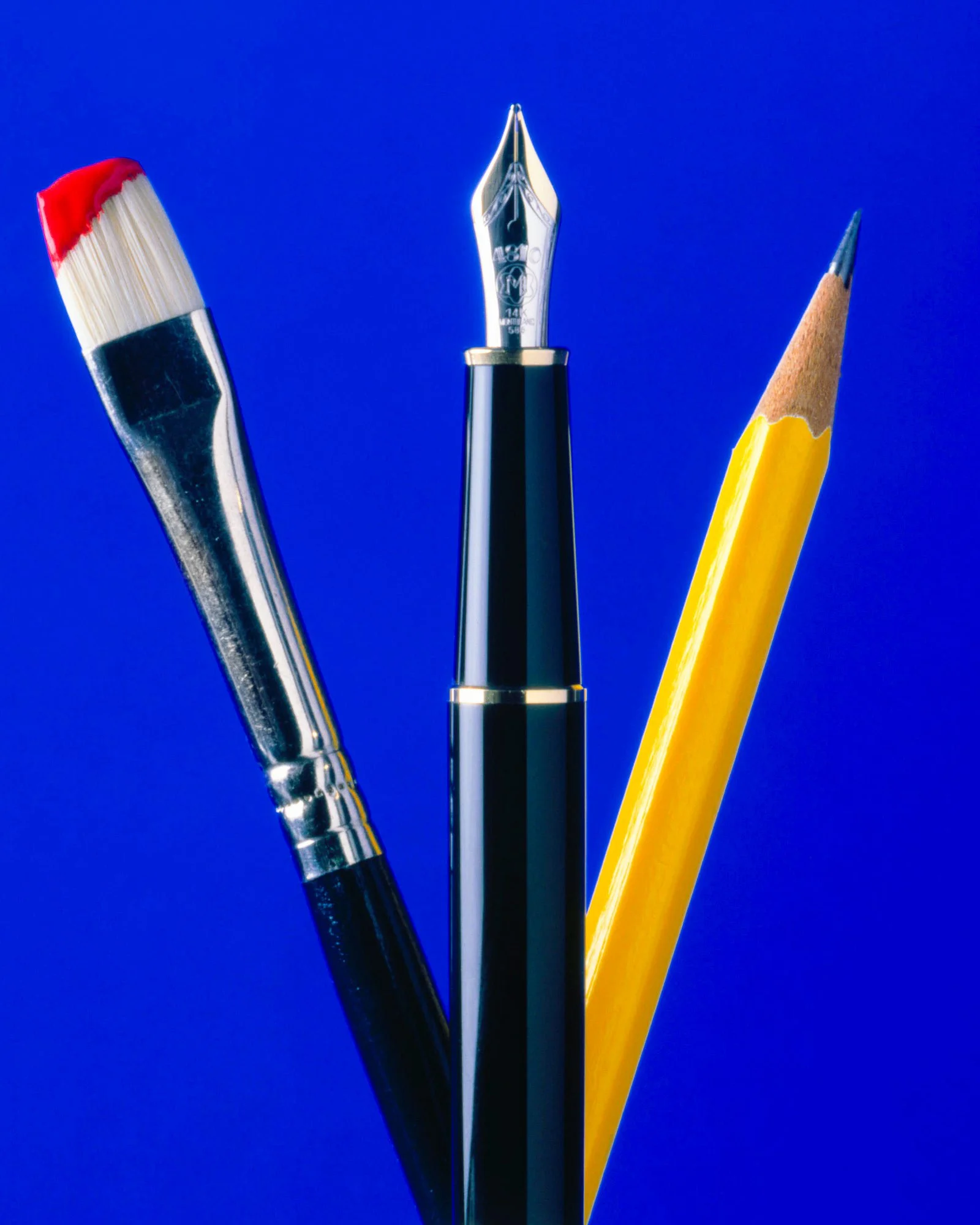 Artist tools photographed against a vivid blue background.