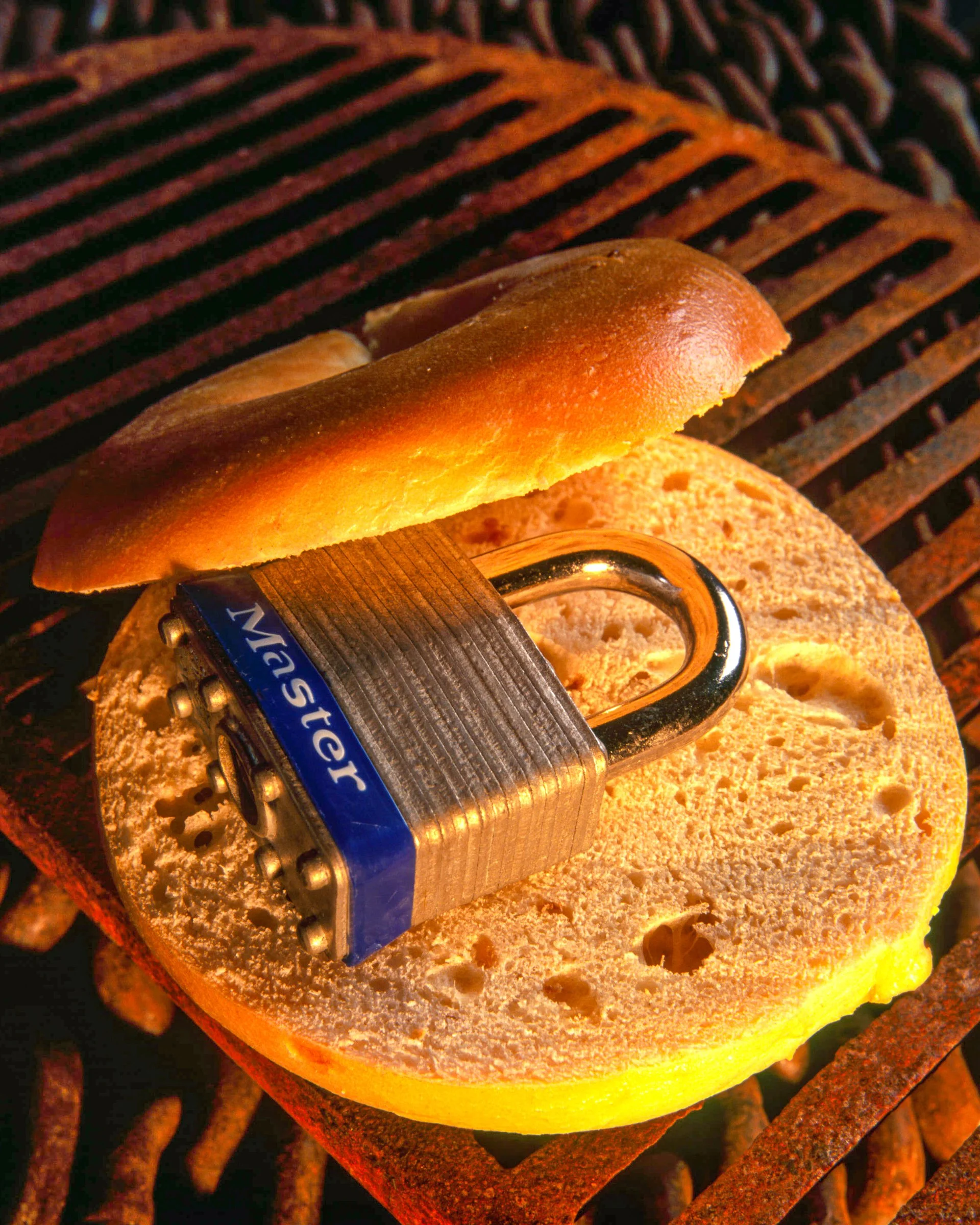 A Master Lock and bagel  styled on a warm-toned surface.