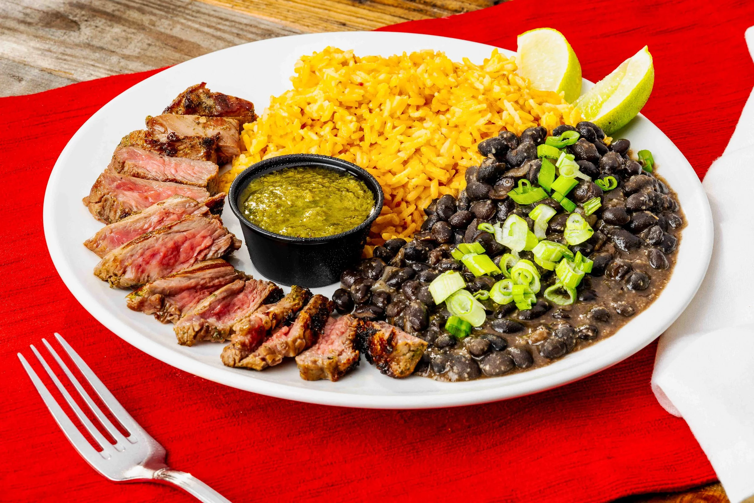 Grilled steak served with rice, and black beans.