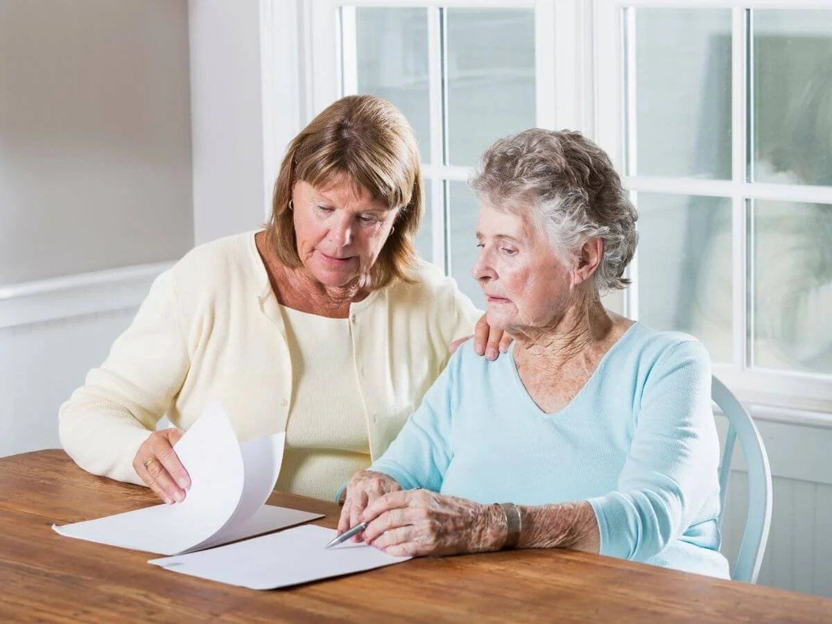 Mother & Daughter Reading Final Expense Insurance Paperwork