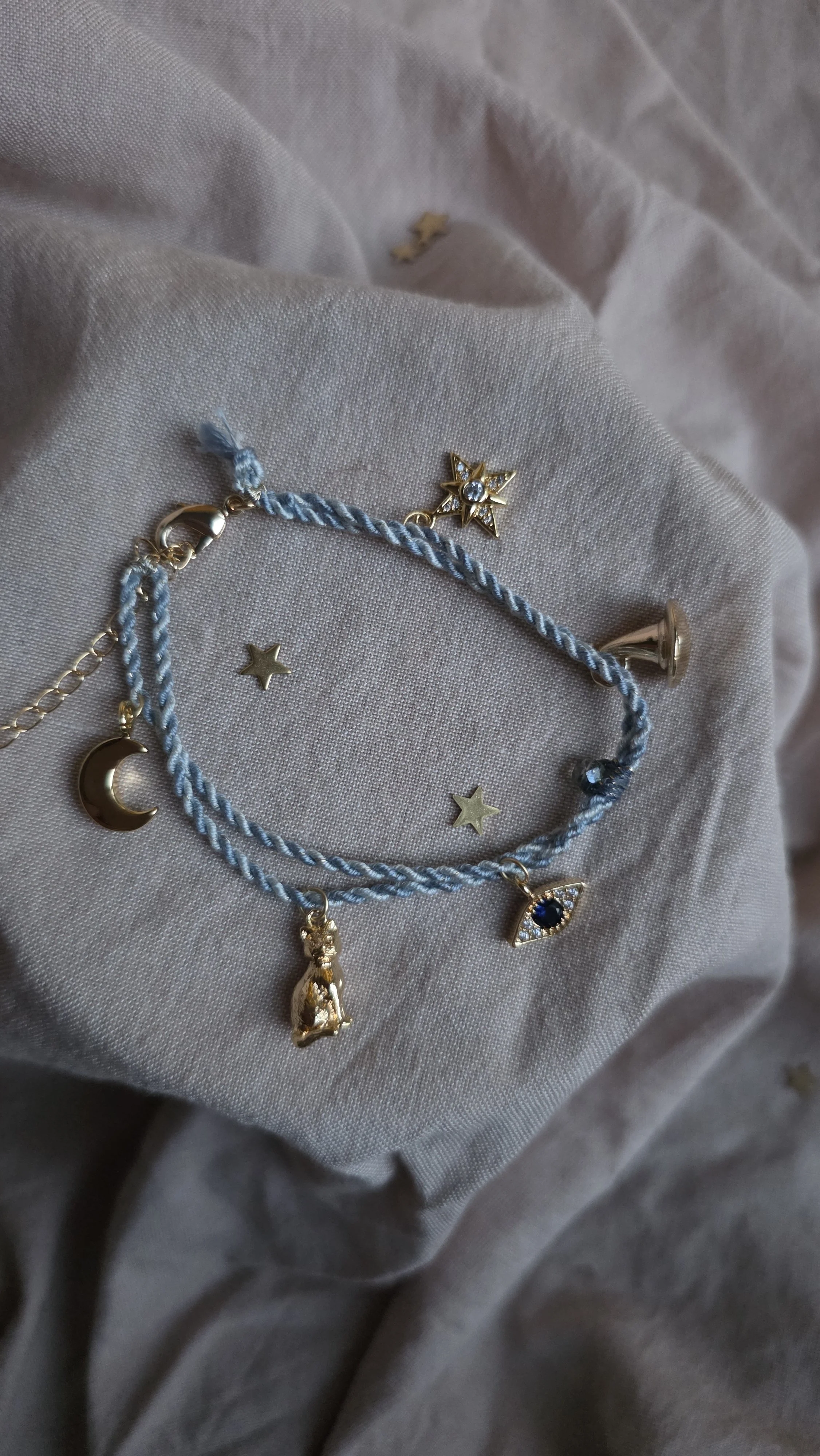 Twisted cord charm bracelet (pale blue with gold tone charms)