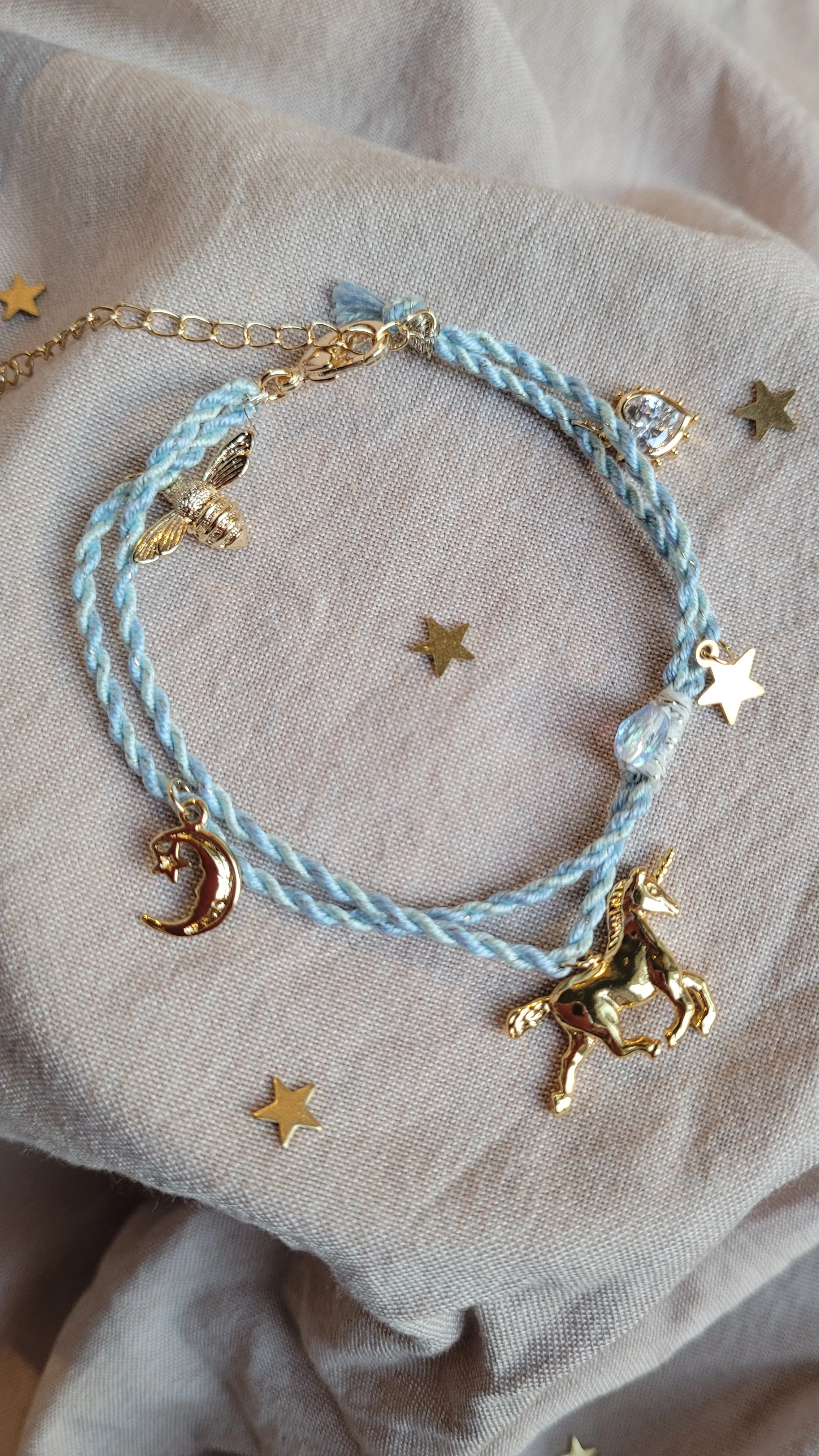Twisted cord charm bracelet (pale blue with gold tone charms)