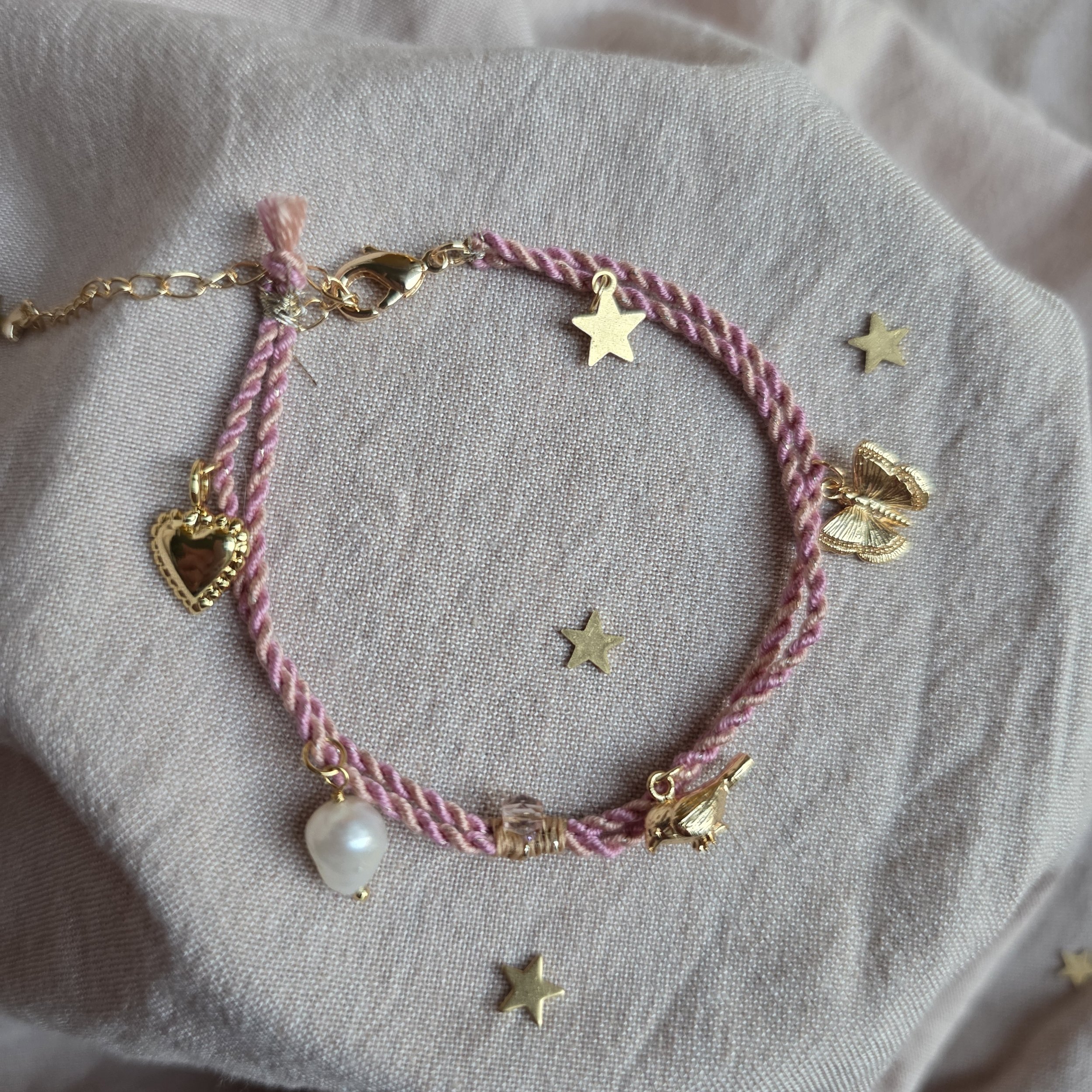 Twisted cord charm bracelet (dusty pink and peach with gold tone charms)