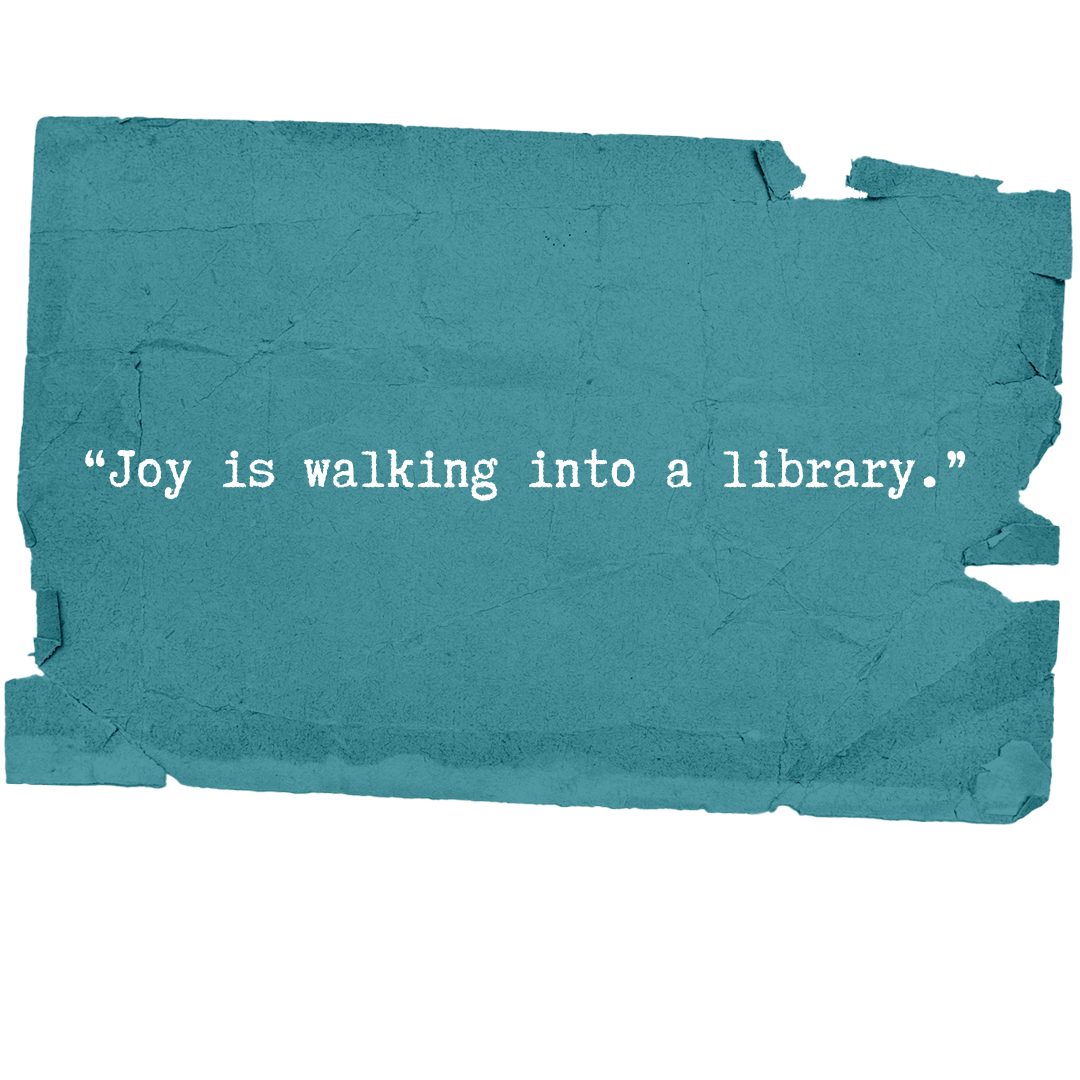 A textured blue paper with a torn edge, displaying the quote 'Joy is walking into a library.'