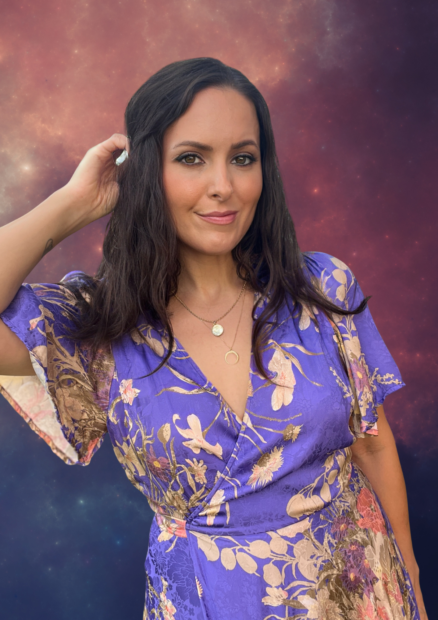 A woman with long dark hair and a floral purple dress, posing against a cosmic starry background.