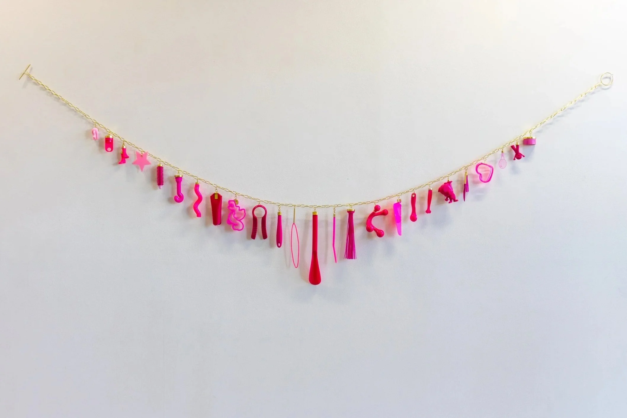Pink Drip, brass, found objects (plastic, silicone, rubber), ready-made brass-plated chain