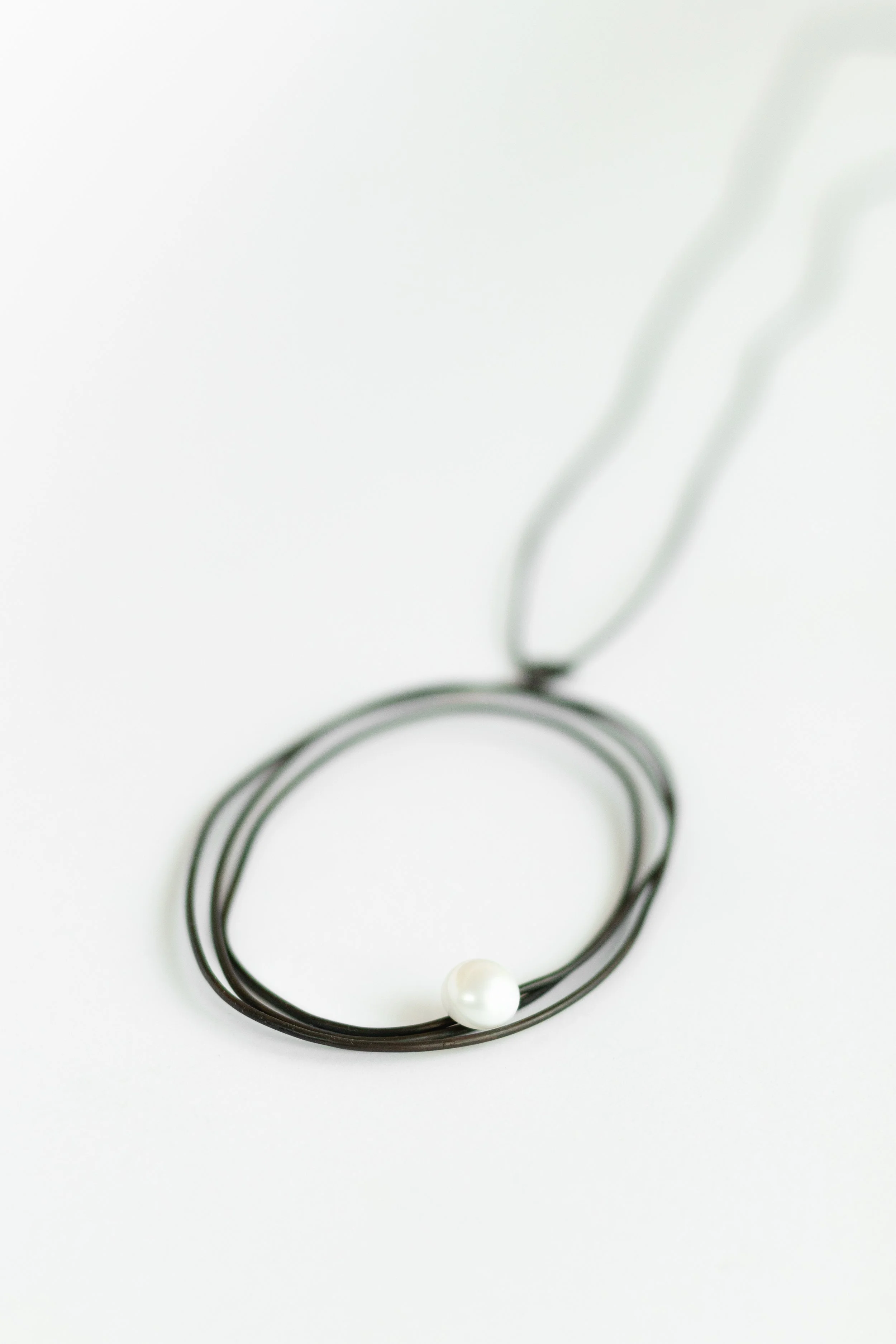 The Amulet, oxidised copper, cultivated freshwater pearl, waxed cotton cord