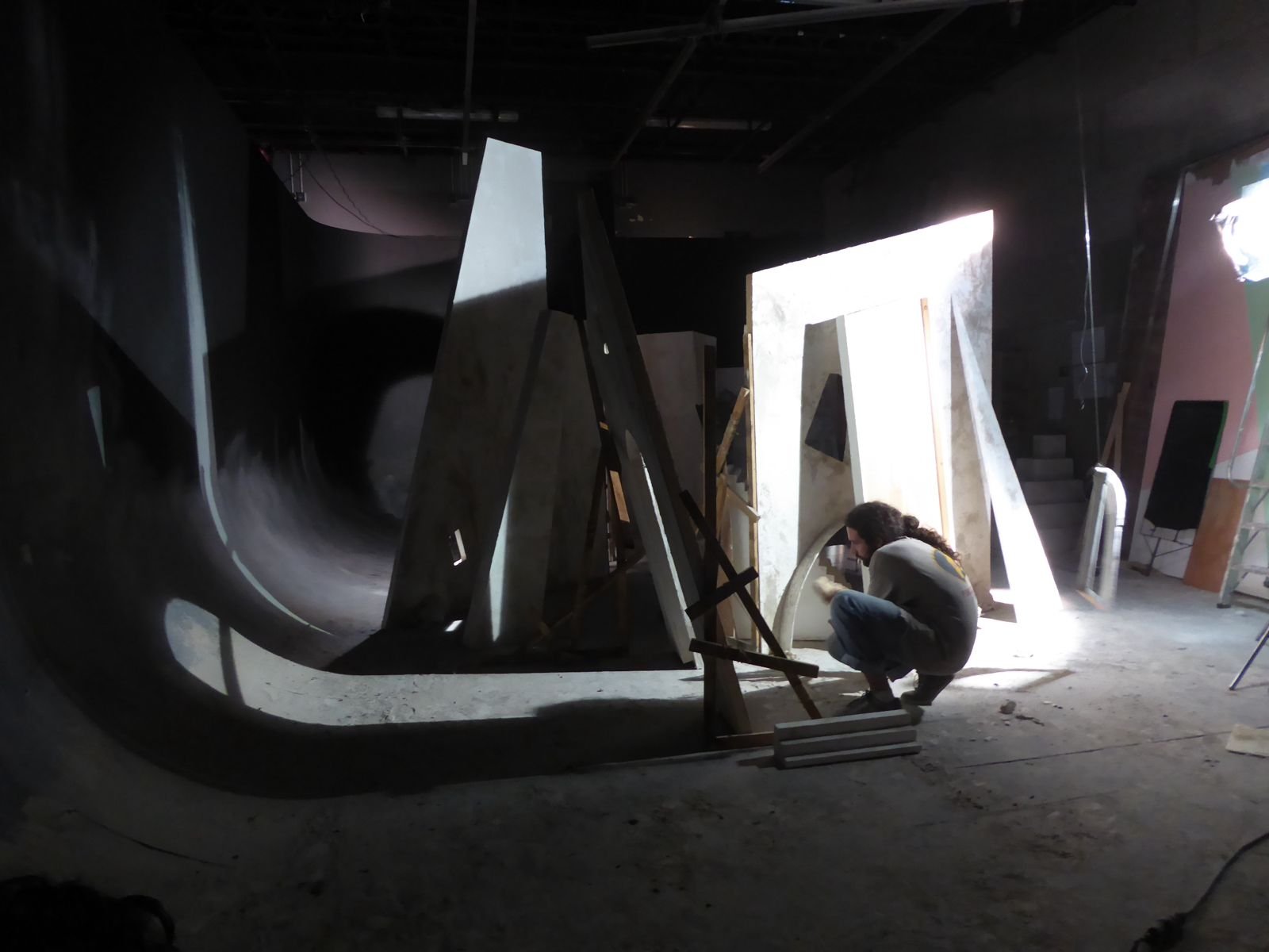 Persona trabajando en un taller de carpintería con puertas y marcos de madera en construcción