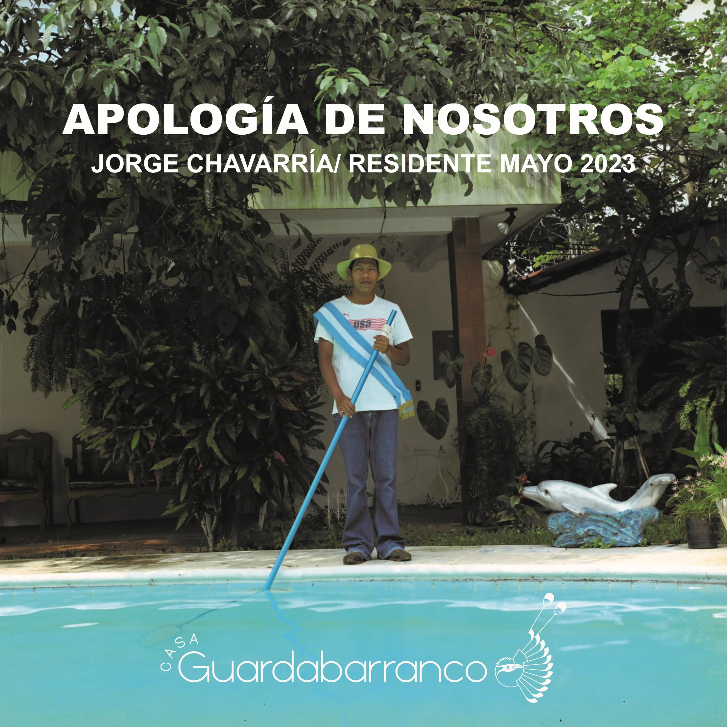 Hombre con gorra y camiseta blanca junto a una piscina, sosteniendo una pértiga y con un trapo en los hombros, en un ambiente rodeado de plantas y un adorno de un pez en la esquina