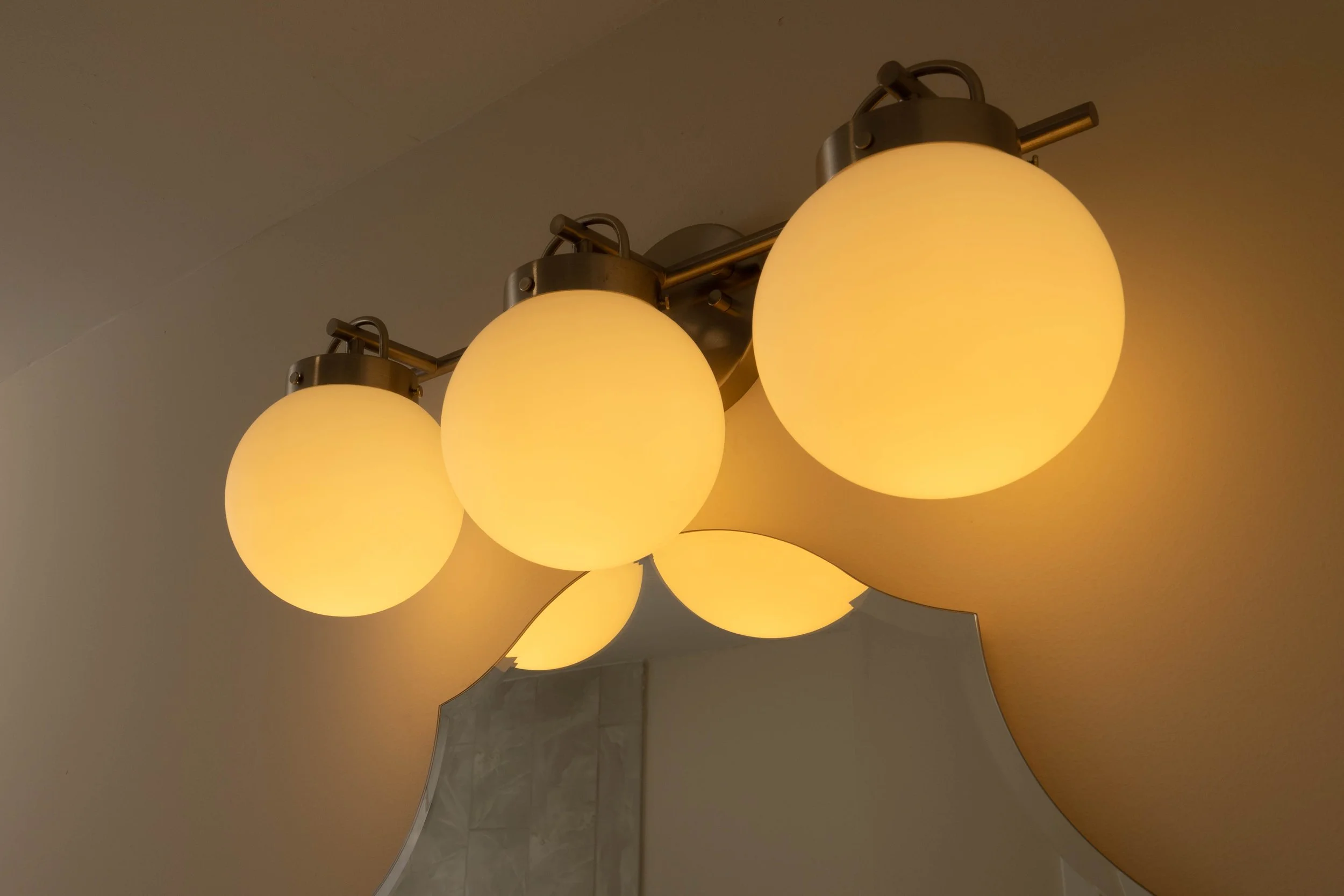 Ceiling light fixture with multiple yellowish glass globes arranged in a cluster.
