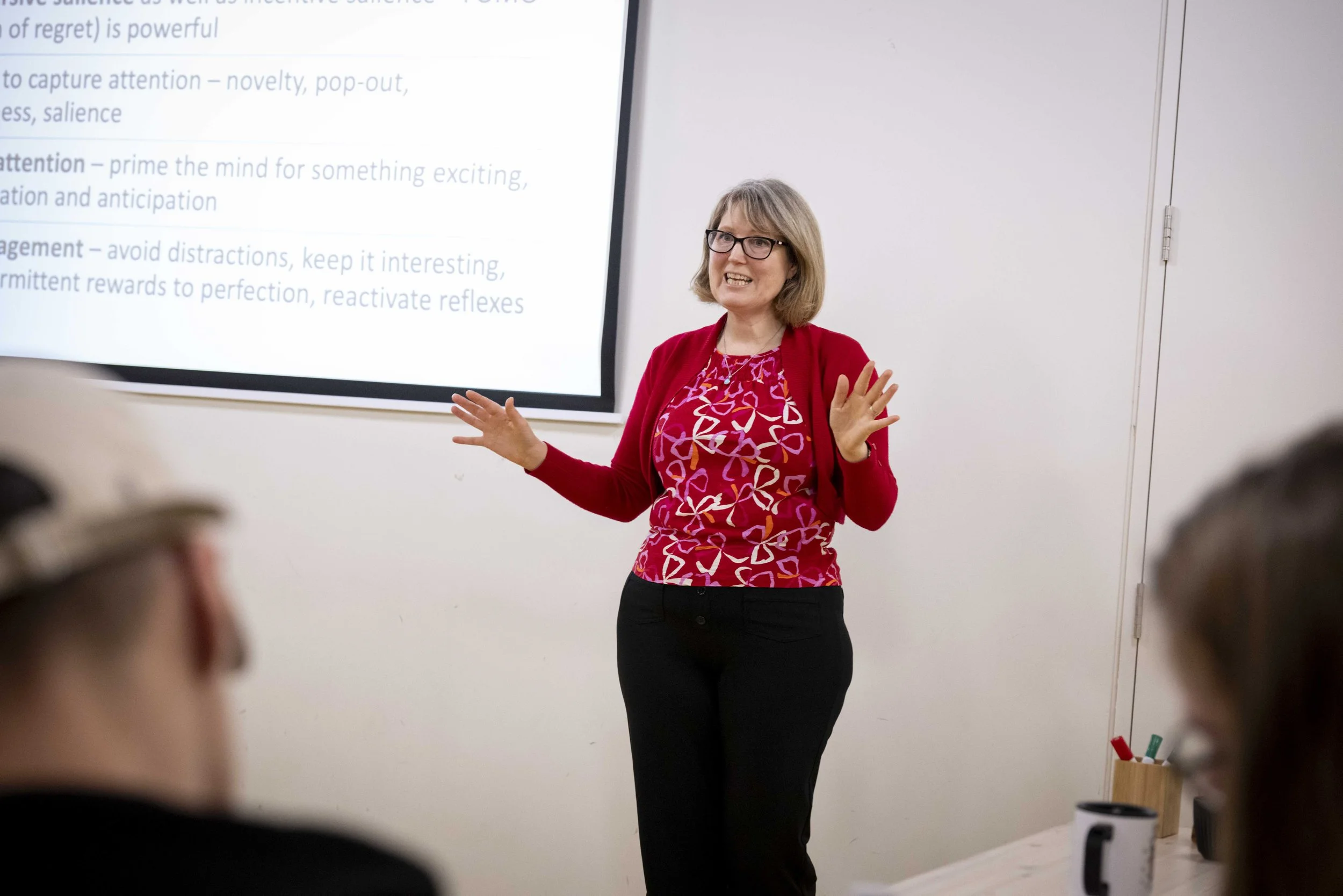 Professor Catherine Loveday stands in front of a group of learners at GIEM teaching them about customer psychology and how to use customer behaviour to generate ticket sales.