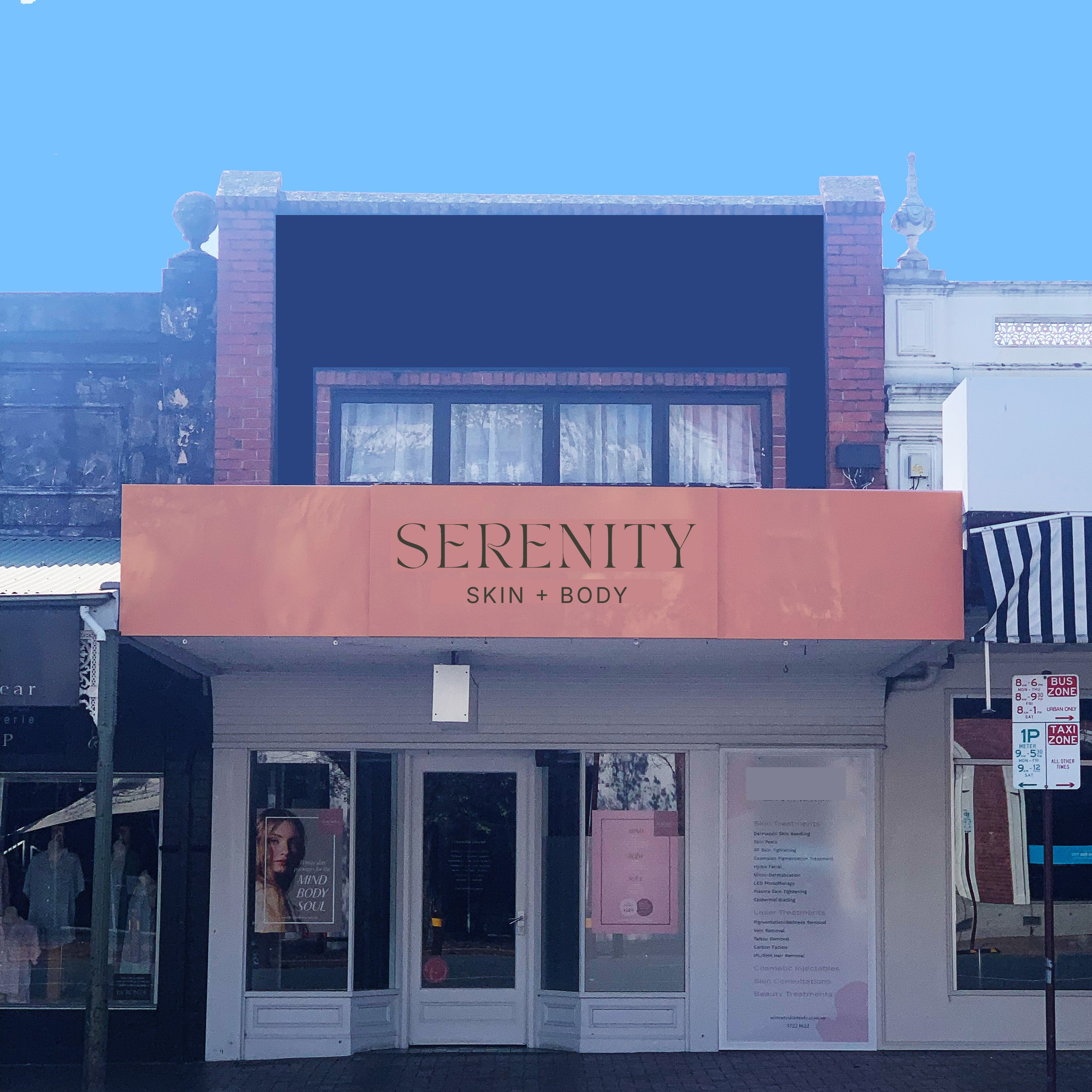 storefront with a large pink sign that reads 'Serenity Skin + Body' and a smaller poster of a woman with the text 'Mind Body Soul' in the window.