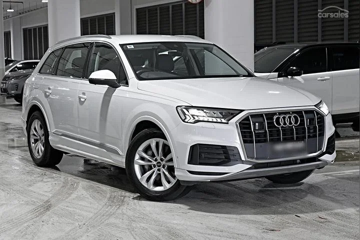 White Audi SUV parked inside a showroom.