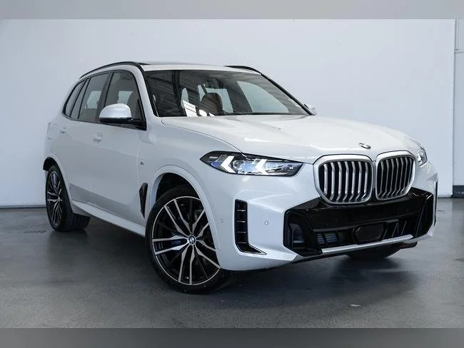 White BMW SUV parked indoors against a plain background.