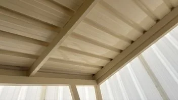 View of a beige metal roof and soffit from below.