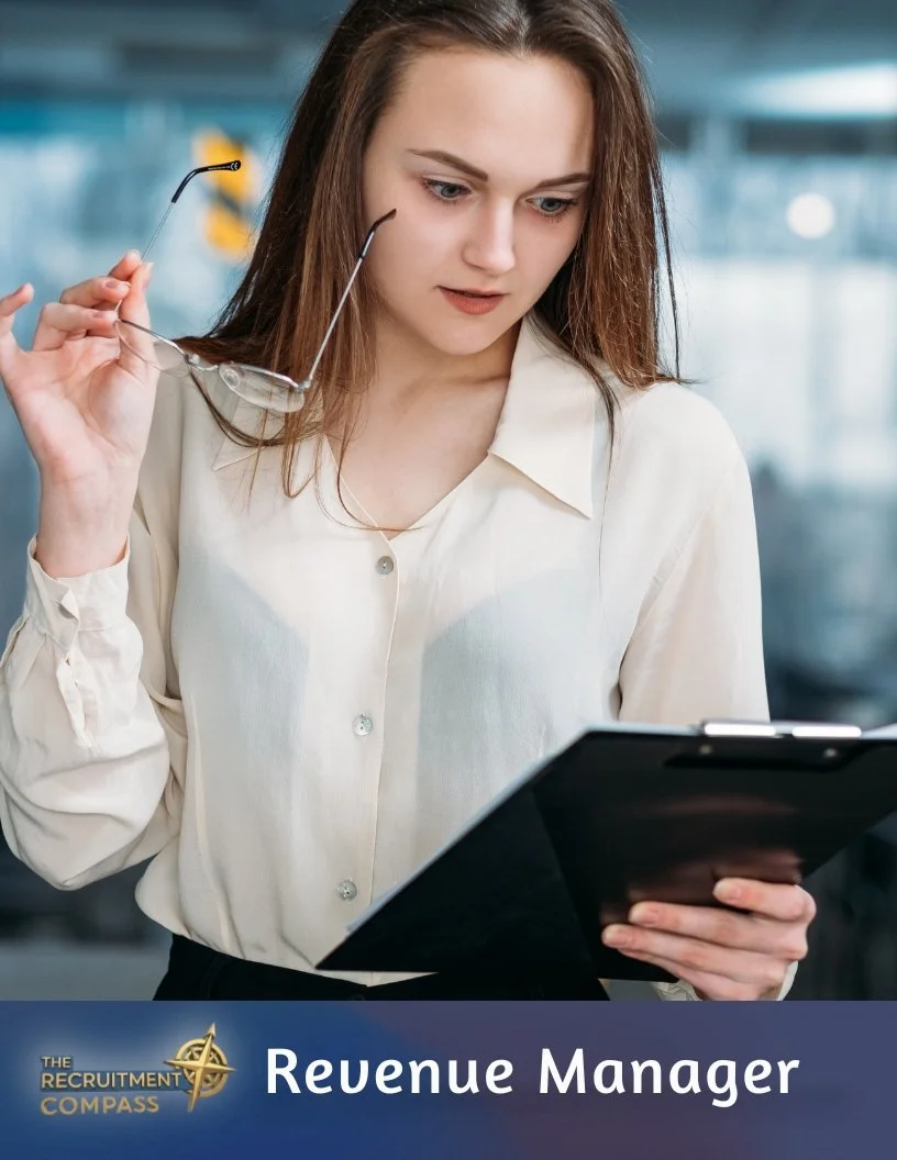A young woman with brown hair, wearing a cream-colored blouse, holding glasses in one hand and a clipboard in the other, looking down thoughtfully. Text at the bottom reads "Revenue Manager" with a logo that says "The Recruitment Compass."