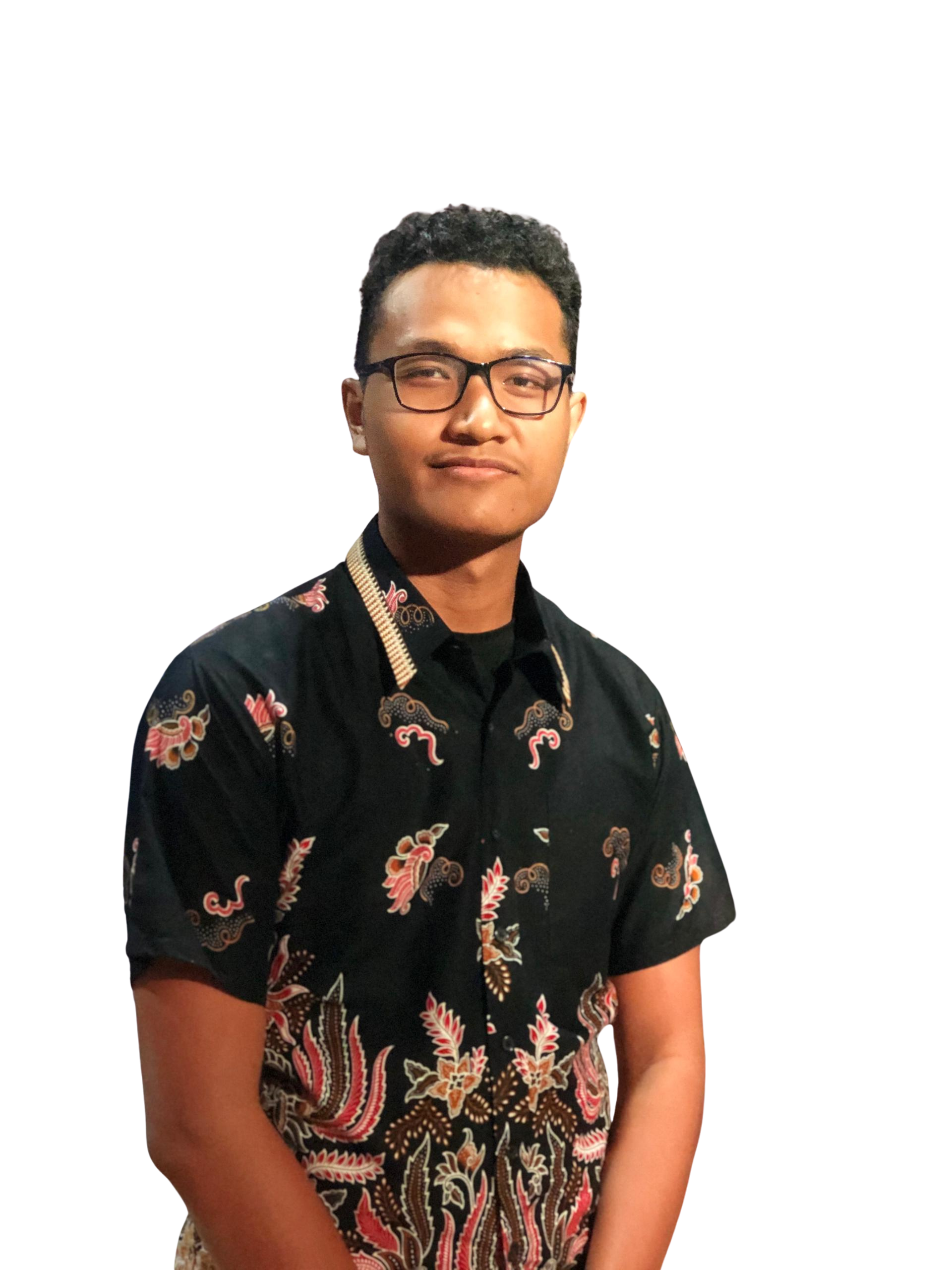 A young man with glasses wearing a black shirt with colorful patterns, standing against a white background.