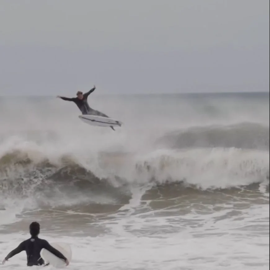 a professional surfer does a 180 degree flip in this video