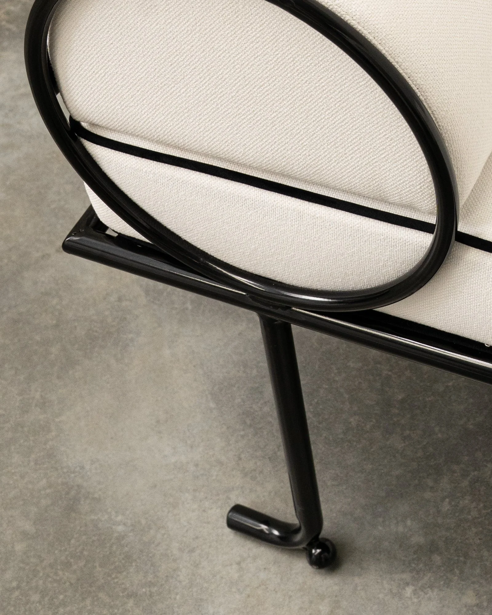 Close-up of a black walker with cushioned seat and wheels on a grey floor.