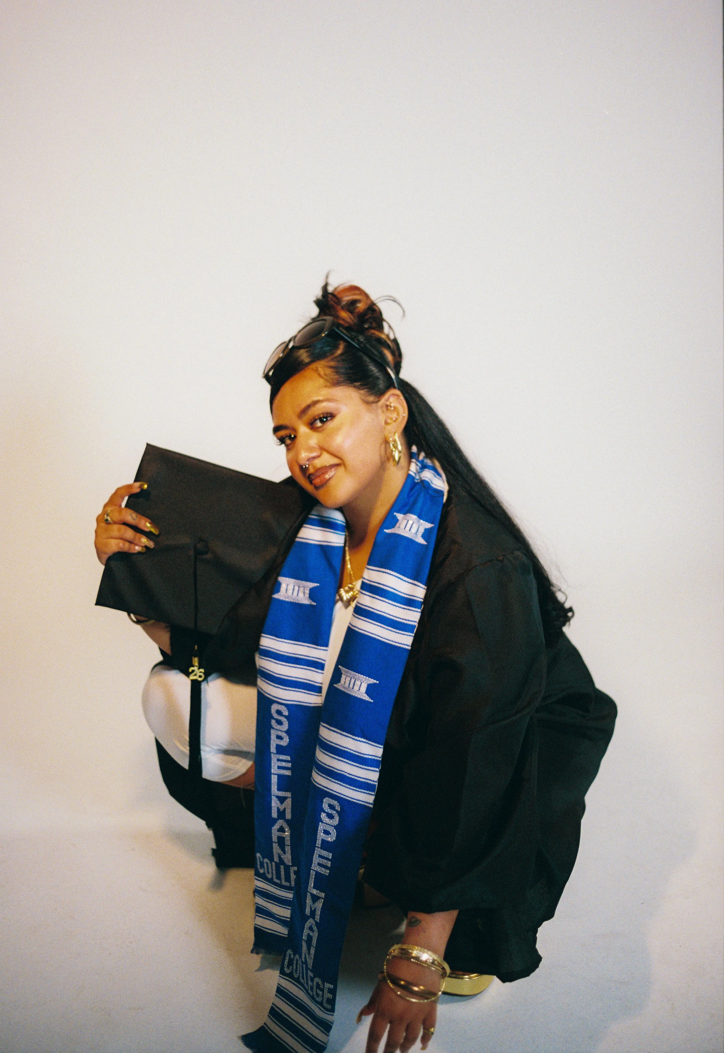 cherish poses with cap and gown in squatting position