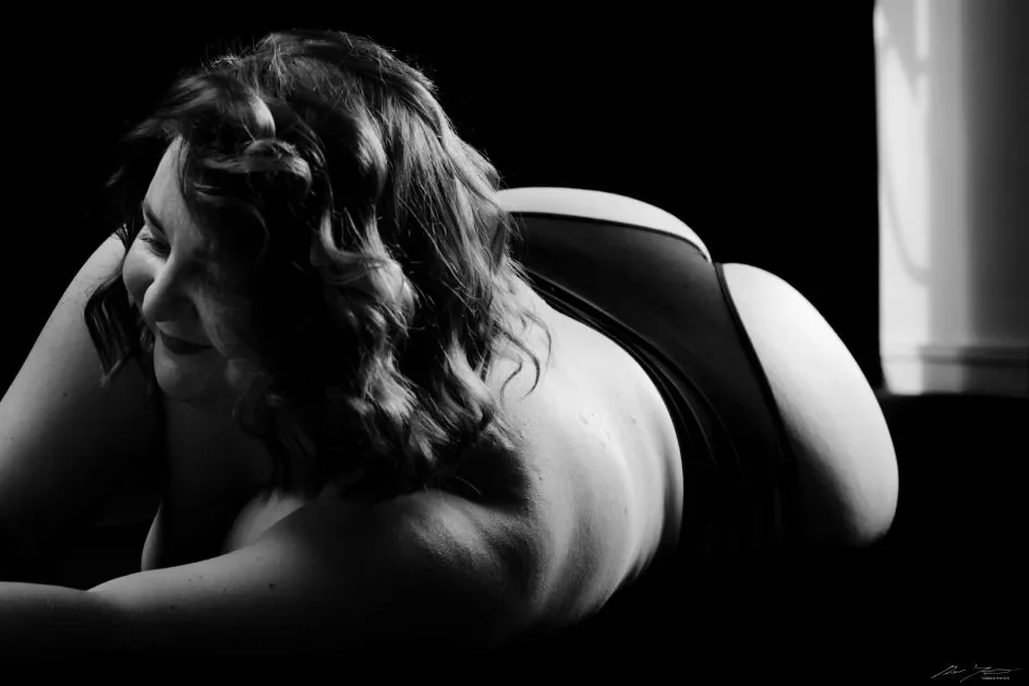 Mustavalkoinen valokuva naisesta makuulla.