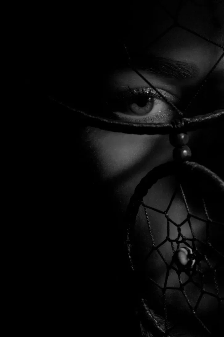 Mustavalkoinen lähikuva, jossa henkilö katsoo suoraan kameraan.