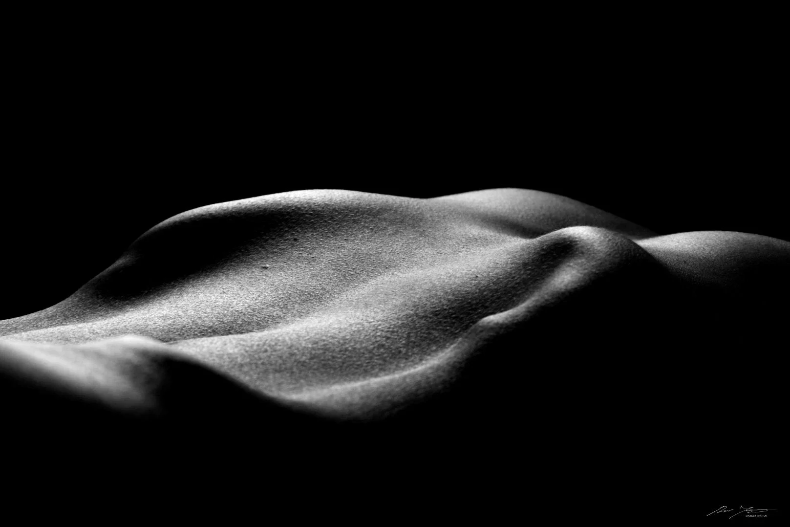 Mustavalkoinen taiteellinen kuva, jossa kuvattu osa ihmisen vartalosta.