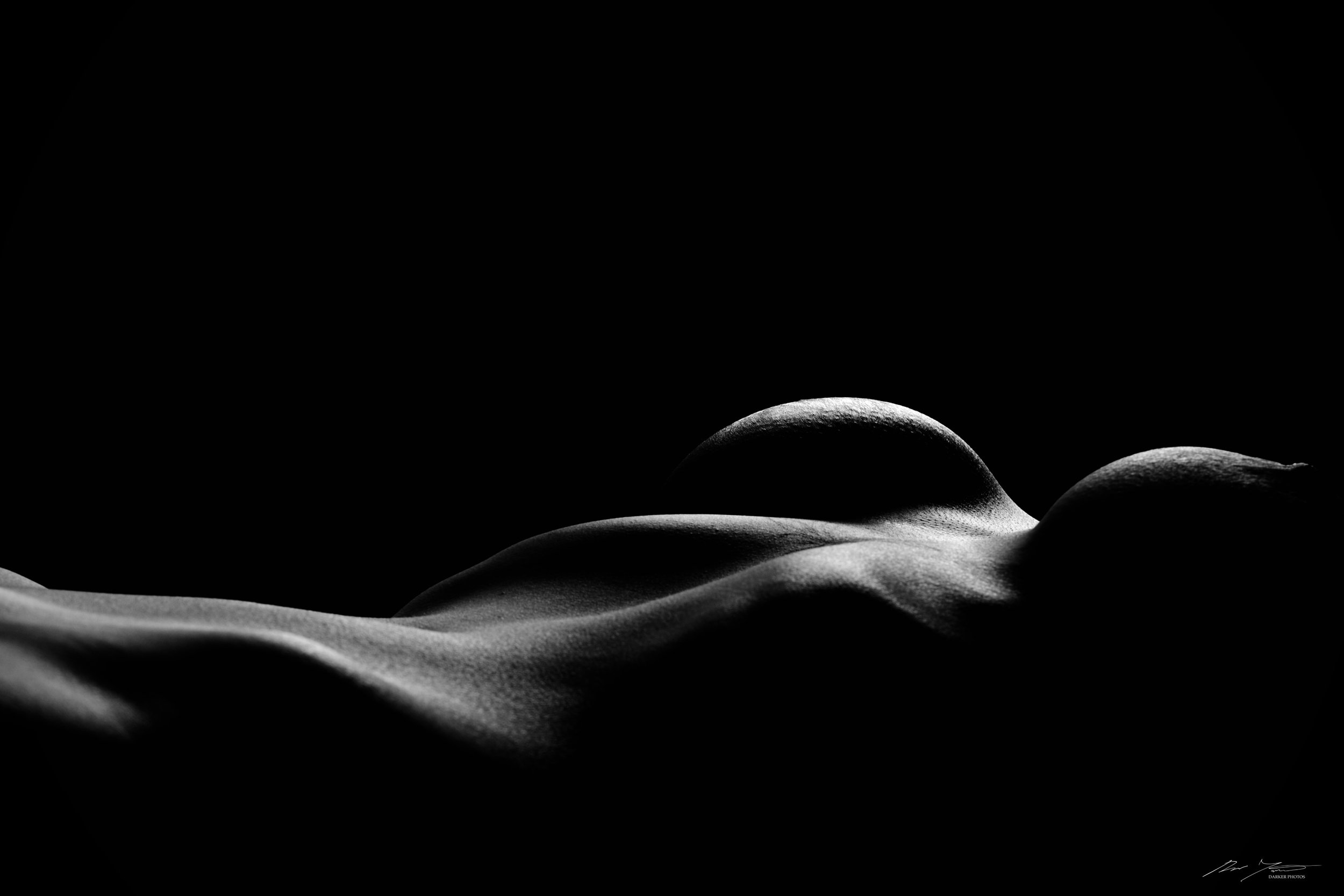 Fine art nude -valokuva naisen vatsasta ja rinnoista.