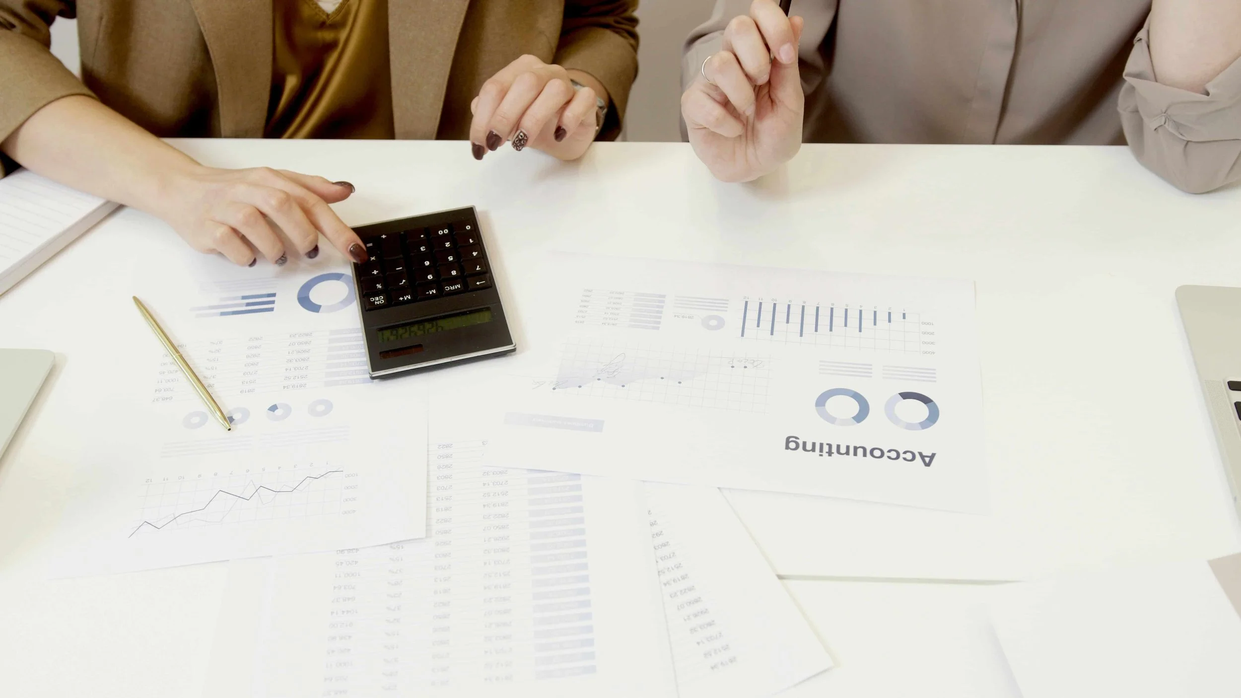 Accountant reviewing financial reports and calculator at desk