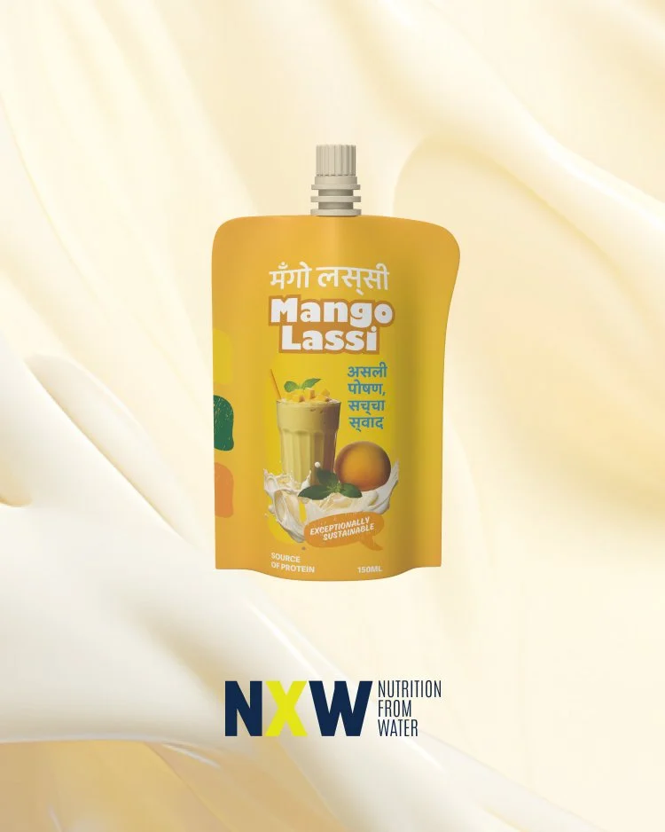 A bright yellow Tetra Pak carton of Mango Lassi drink, with images of a mango, a milkshake glass, and a splash of milk on the front, and text in English and Hindi.